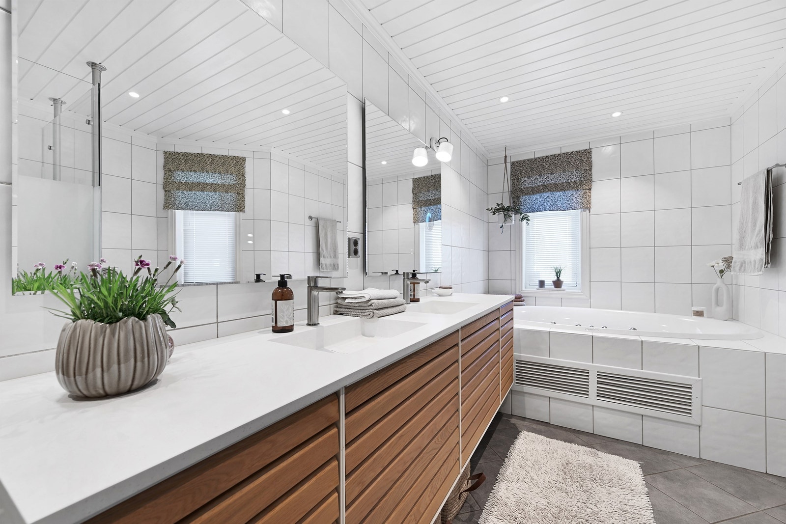 Hovedbadet i første etasje har innredning fra 2021, med doble servanter, innfliset badekar og vannbåren gulvvarme. Galleribilde