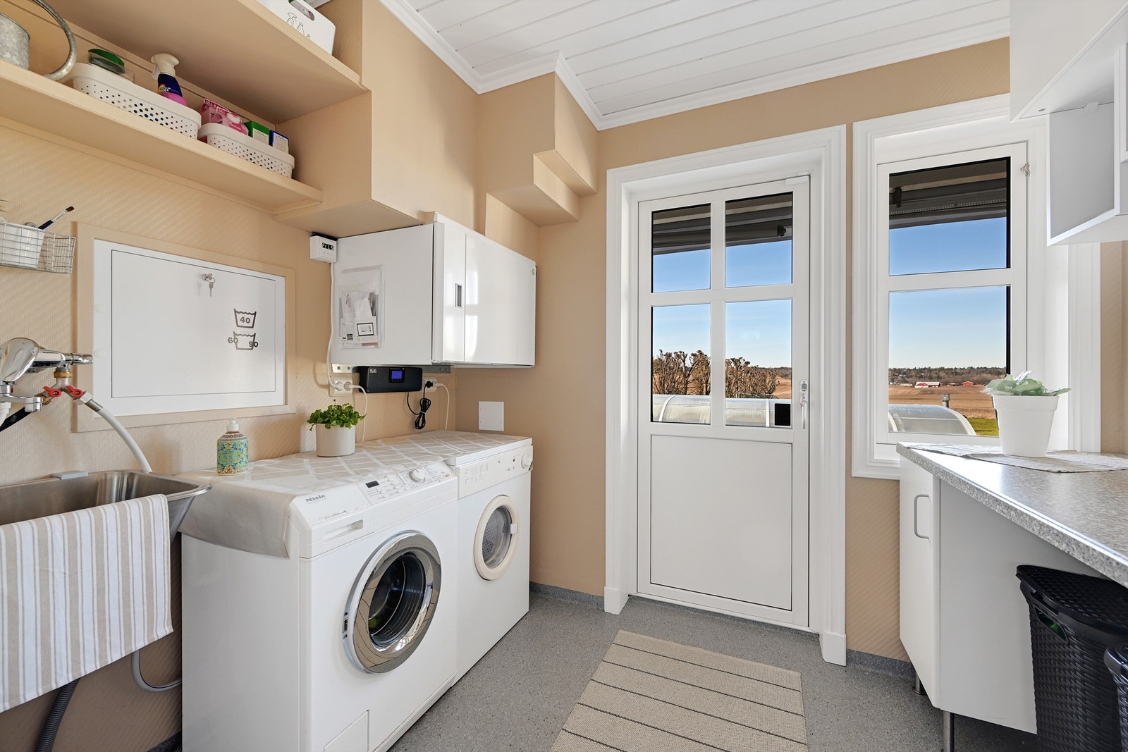 Vaskerommet har egen inngang, opplegg for vaskemaskin og tørketrommel, og huser det balanserte ventilasjonsaggregatet fra 2022. Galleribilde