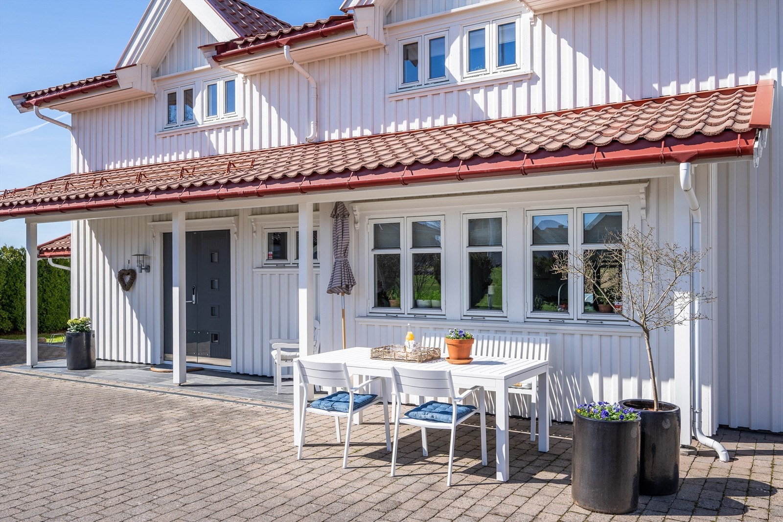 En hyggelig uteplass ved inngangspartiet, med belegningsstein på gårdsplassen. Galleribilde