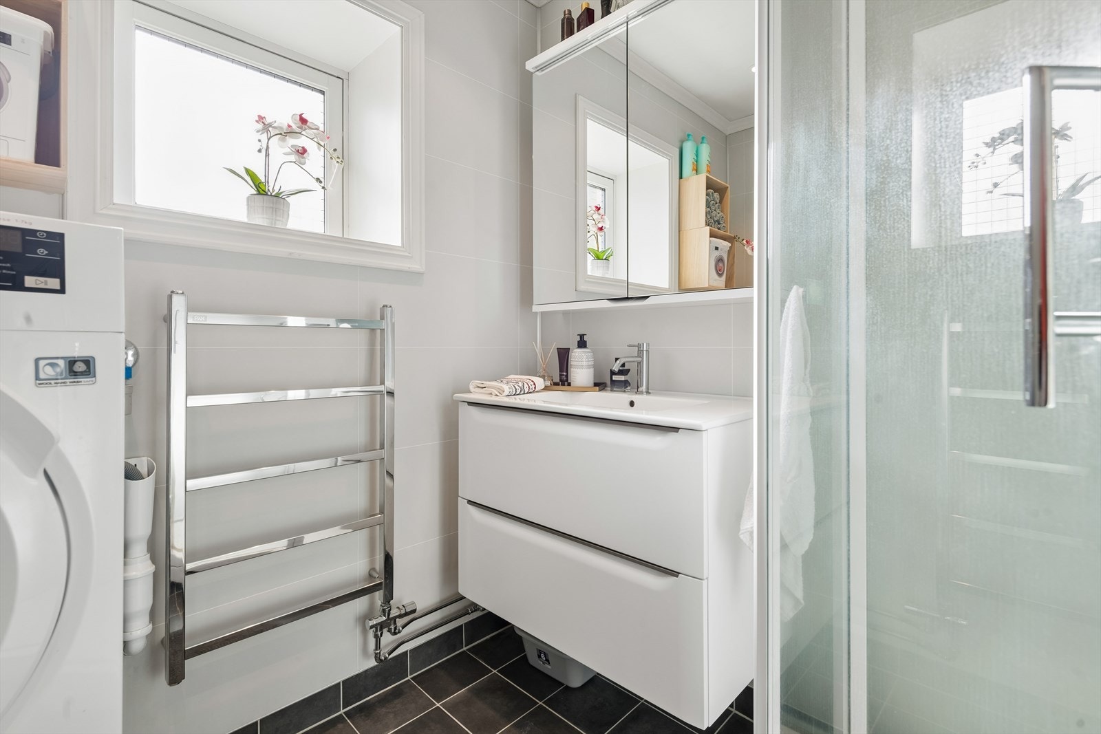 Badet inneholder baderomsinnredning, overskap m/speildører, vegghengt toalett og dusjkabinett. Galleribilde