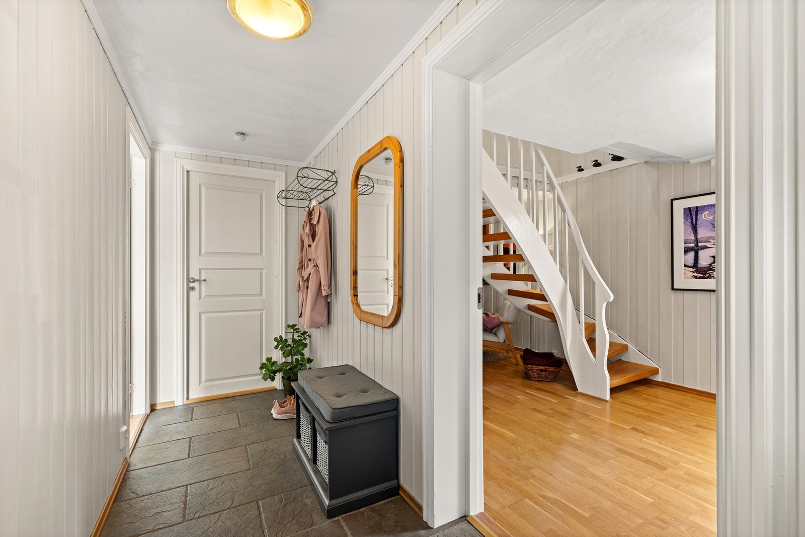 Lys og pen entré med fliser på gulv samt varmekabler. Galleribilde