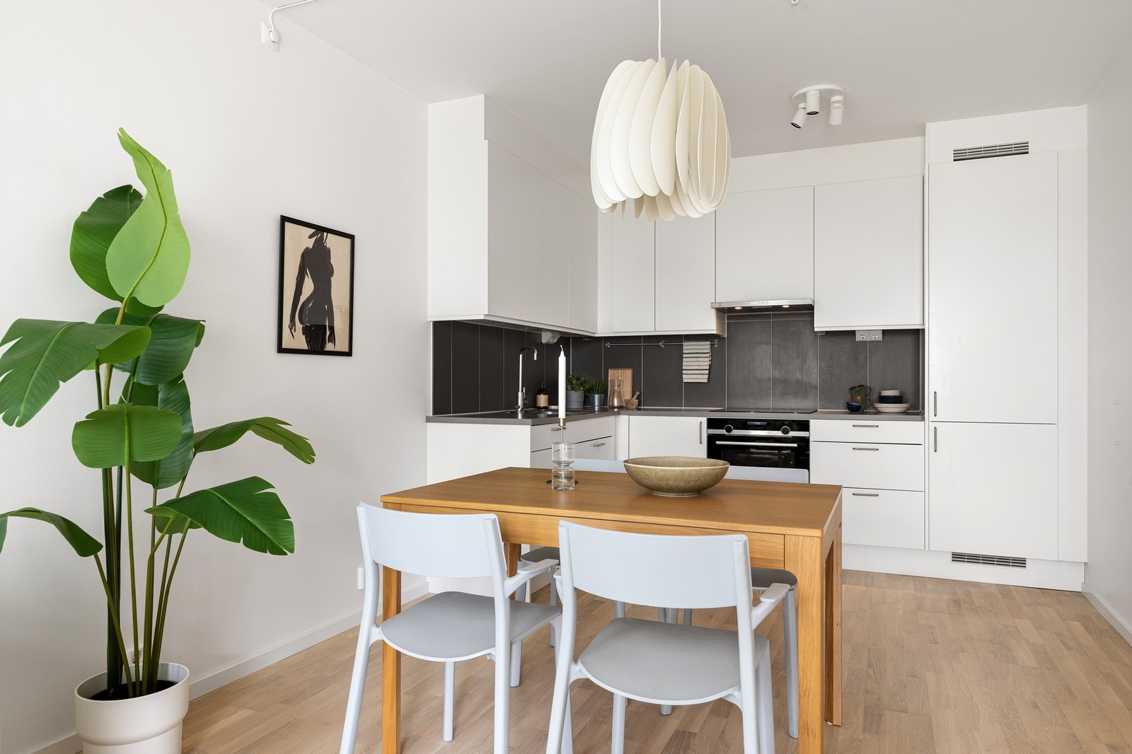 Moderne kjøkkeninnredning fra Marbodal (2022) med hvite, glatte fronter og laminat benkeplate med innfelt vaskekum i børstet stål. Galleribilde