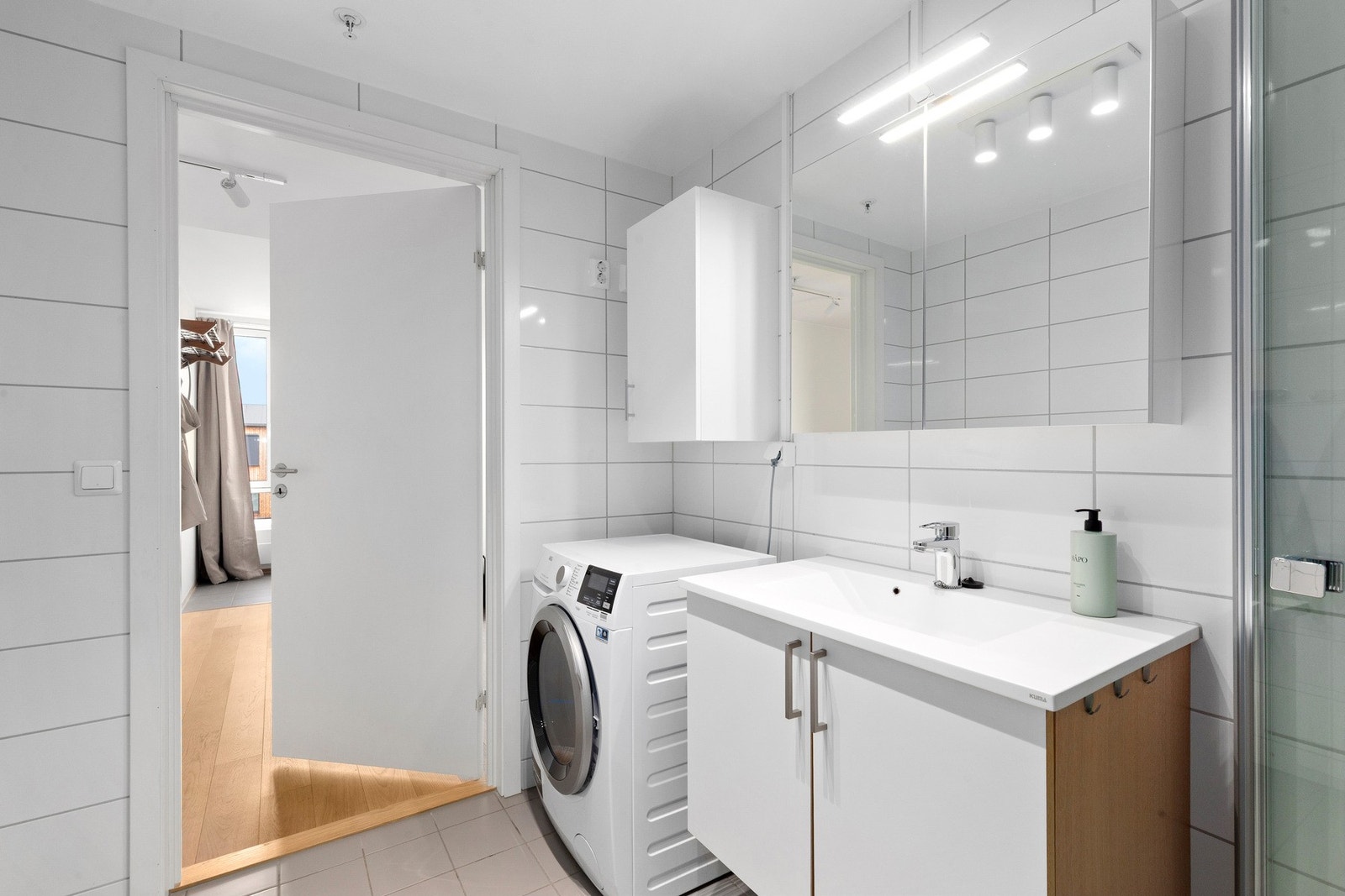 Badet er utstyrt med opplegg for vaskemaskin, dusjhjørne, veggmontert wc, rørfordelingsskap, stoppekran, servant og servantskap. Galleribilde
