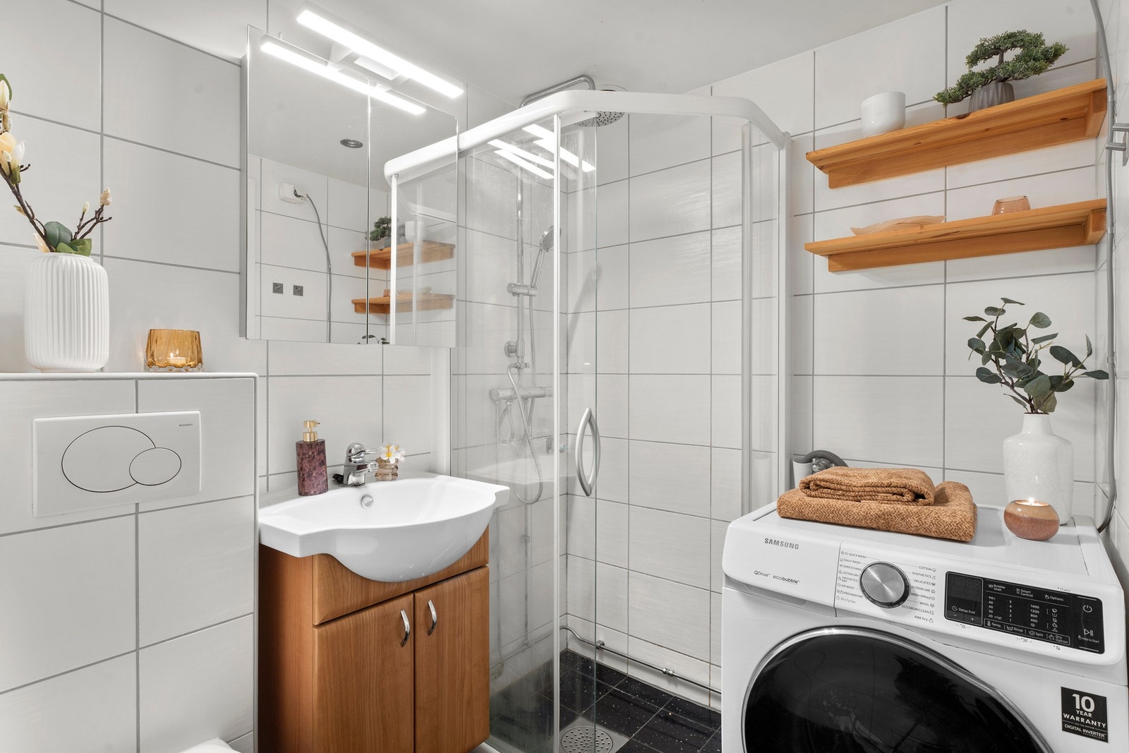 Badet har varmekabler i gulv, samt opplegg for vaskemaskin og praktiske hyller på vegg. Galleribilde