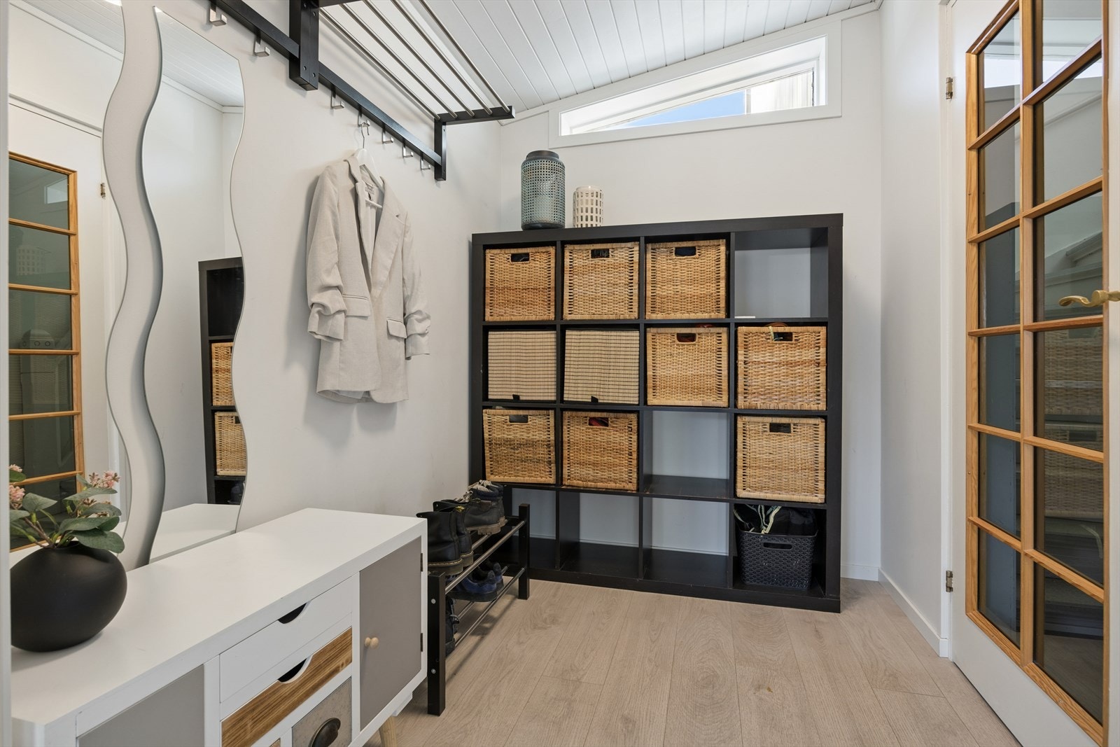 Fra entreen fører en dør med glassfelt inn til resten av boligen, noe som gir en lys og åpen overgang. Galleribilde