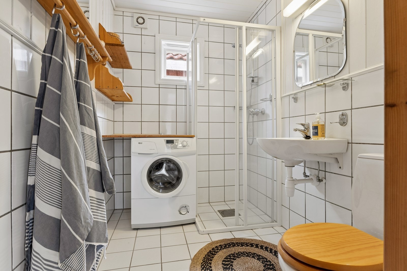 Badet i første etasje er praktisk innredet med dusjnisje, servant, toalett og opplegg for vaskemaskin. Galleribilde