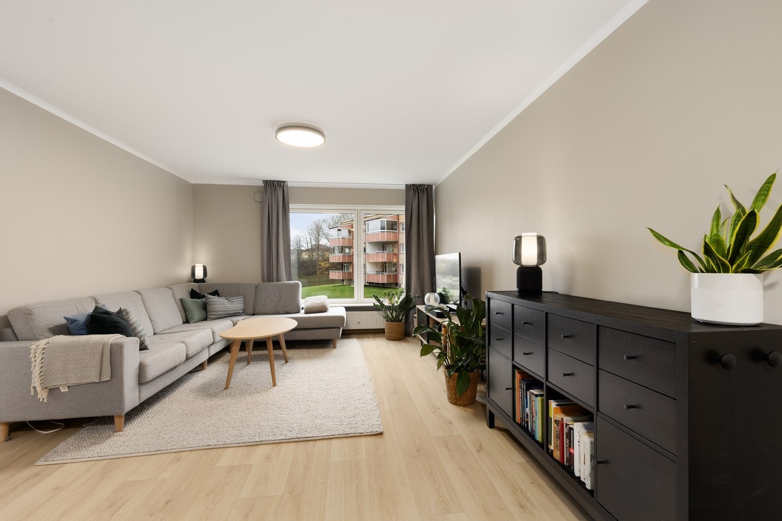 Stuen er malt i en behagelig lun farge og har store vindusflater som slipper inn rikelig med naturlig lys. Under stuevinduene er det montert vannbåren radiator for oppvarming. Galleribilde