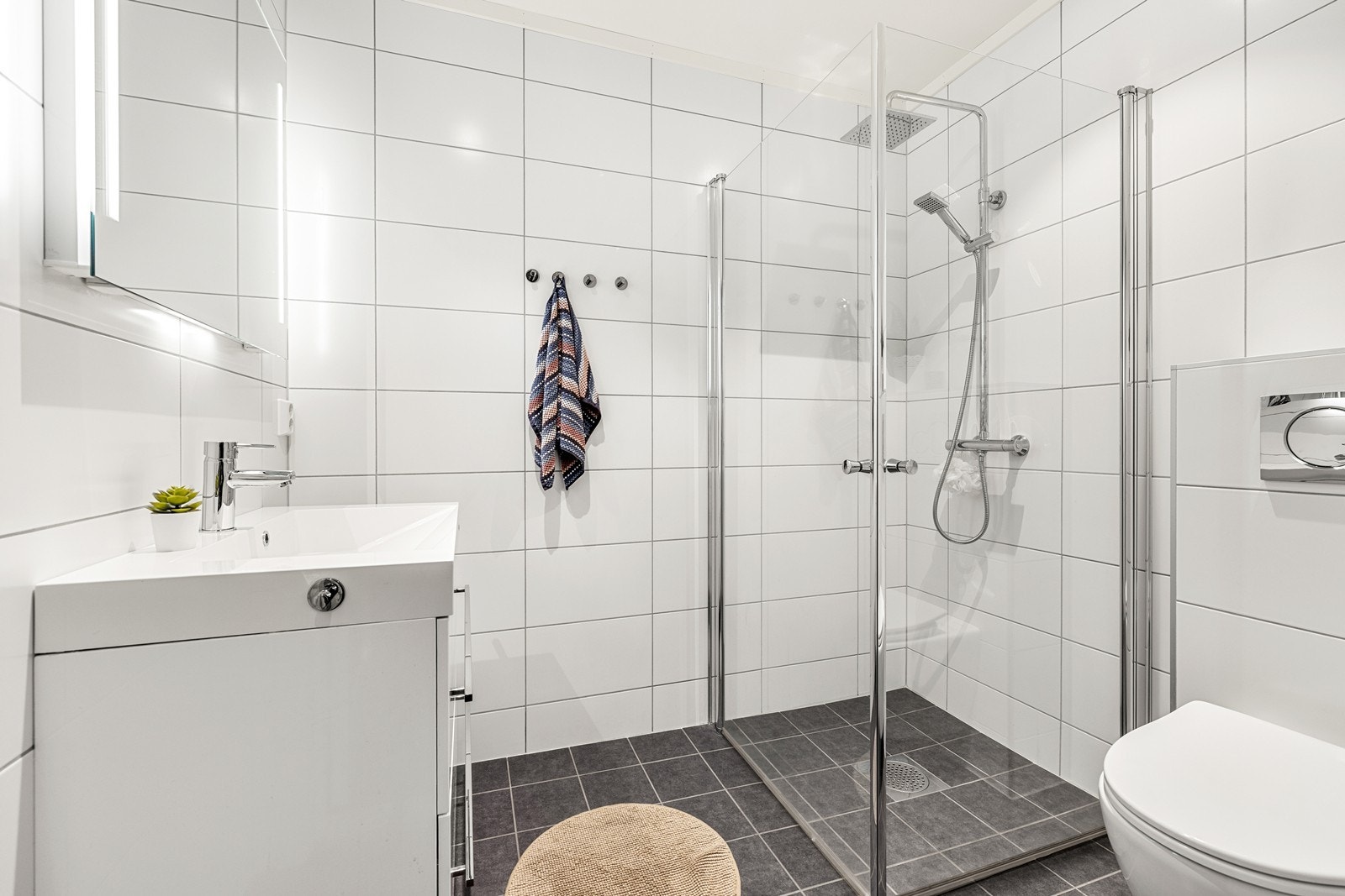 Delikat bad med flislagte overflater og elektriske varmekabler. Innredet med servant, toalett og dusjhjørne. Galleribilde