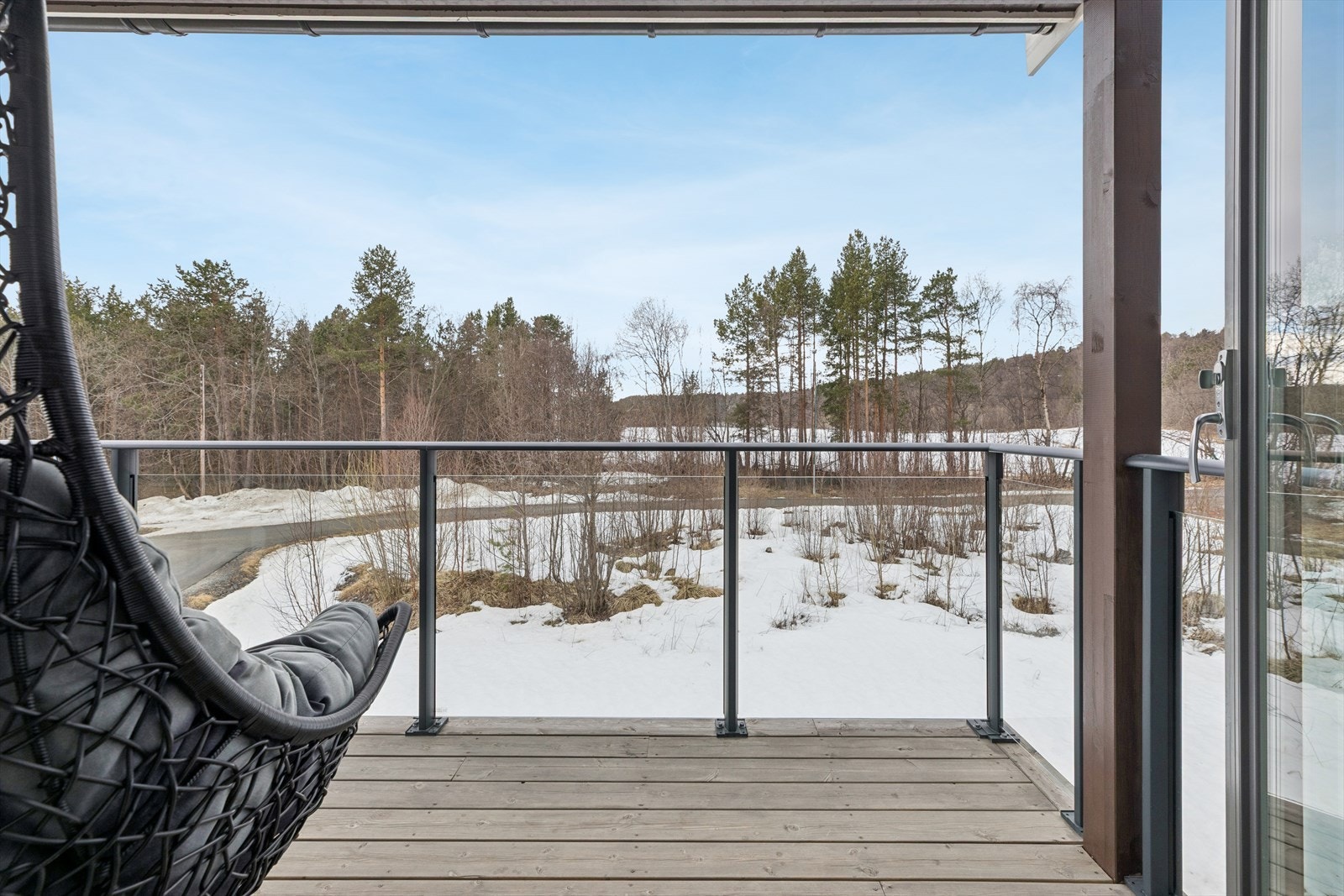 Balkongen er bygget med impregnert terrassebord og har et stilrent rekkverk i glass og metall. Galleribilde