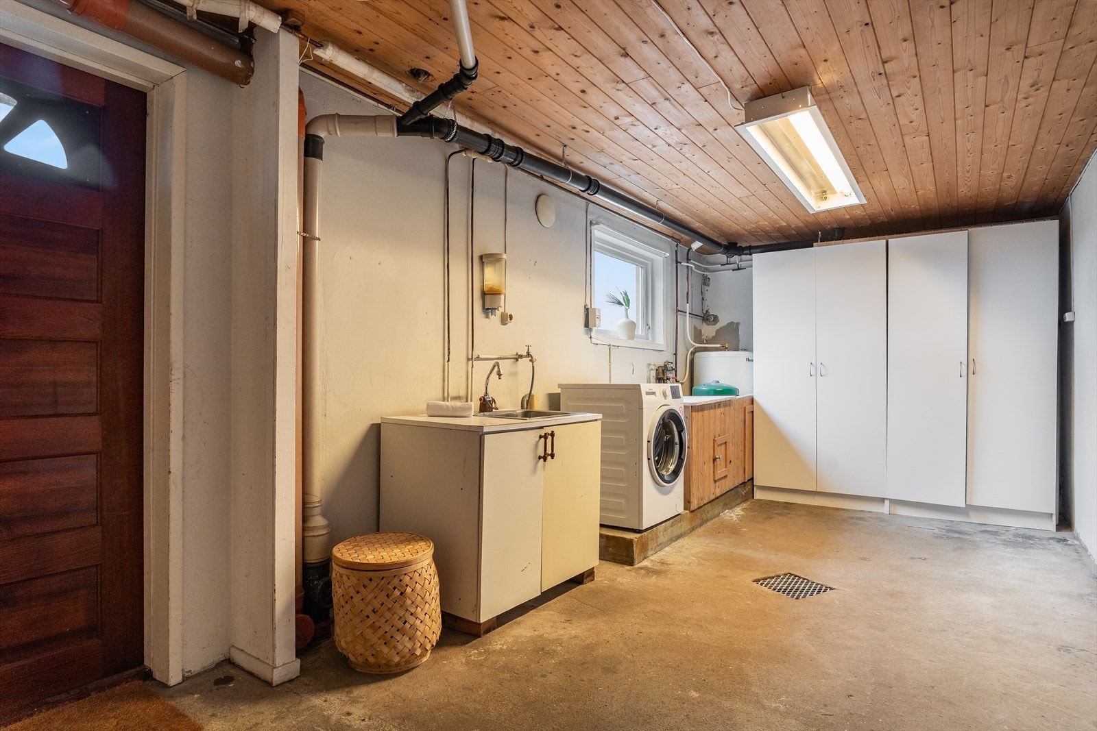 Romslig vaskerom med opplegg til vaskemaskin/tørketrommel, utslagsvask, innredning og garderobe. Galleribilde