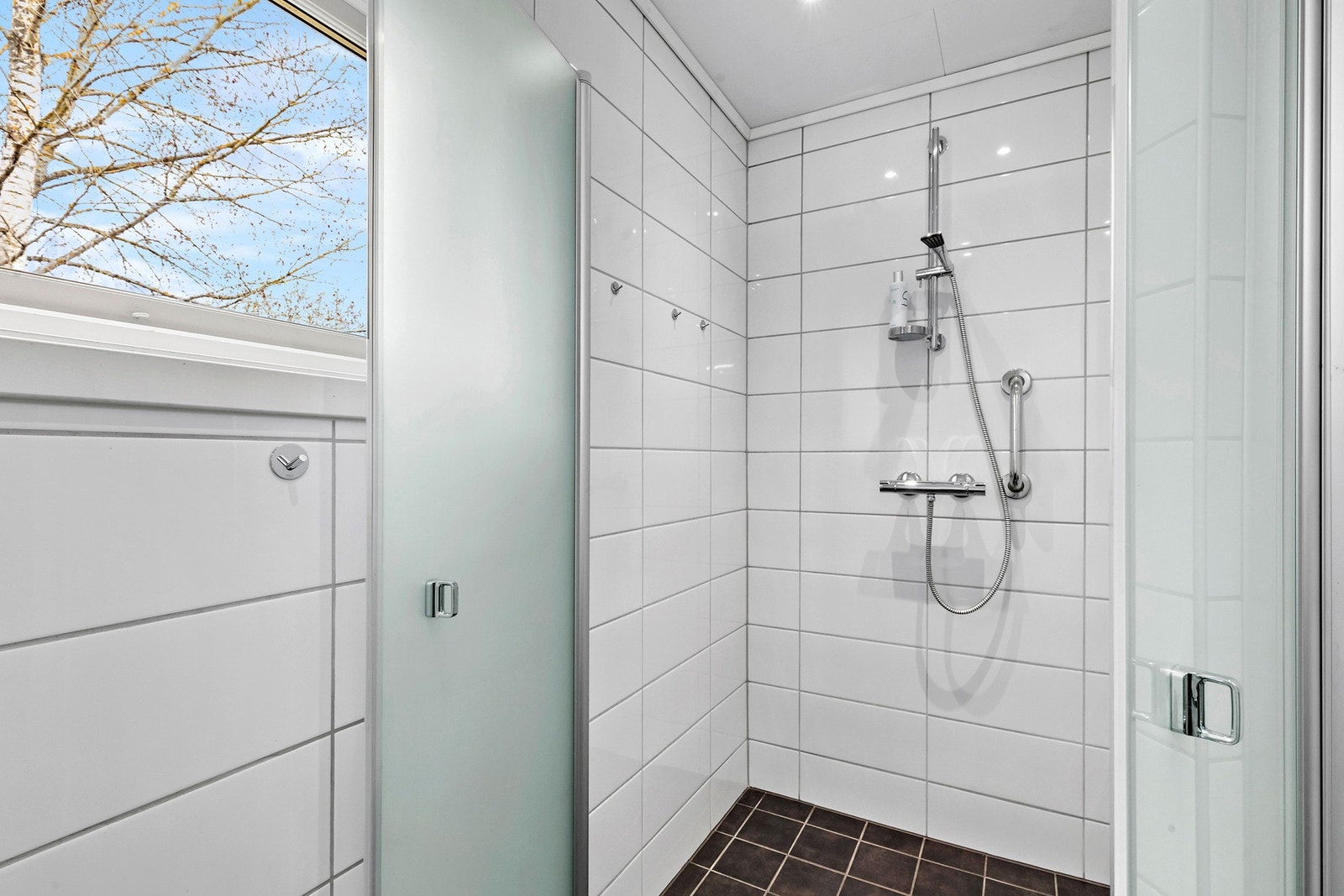 Badet er innredet med vegghengt WC, dusjhjørne og servant med underskap Galleribilde