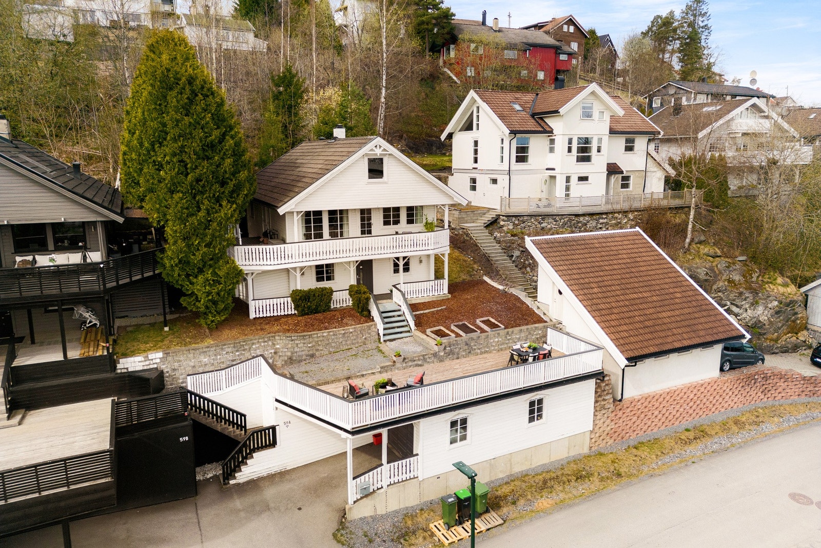 Tomten er pent opparbeidet med asfaltert oppkjørsel, plenarealer og variert beplantning som gir et grønt og hyggelig uttrykk gjennom sesongen. Galleribilde