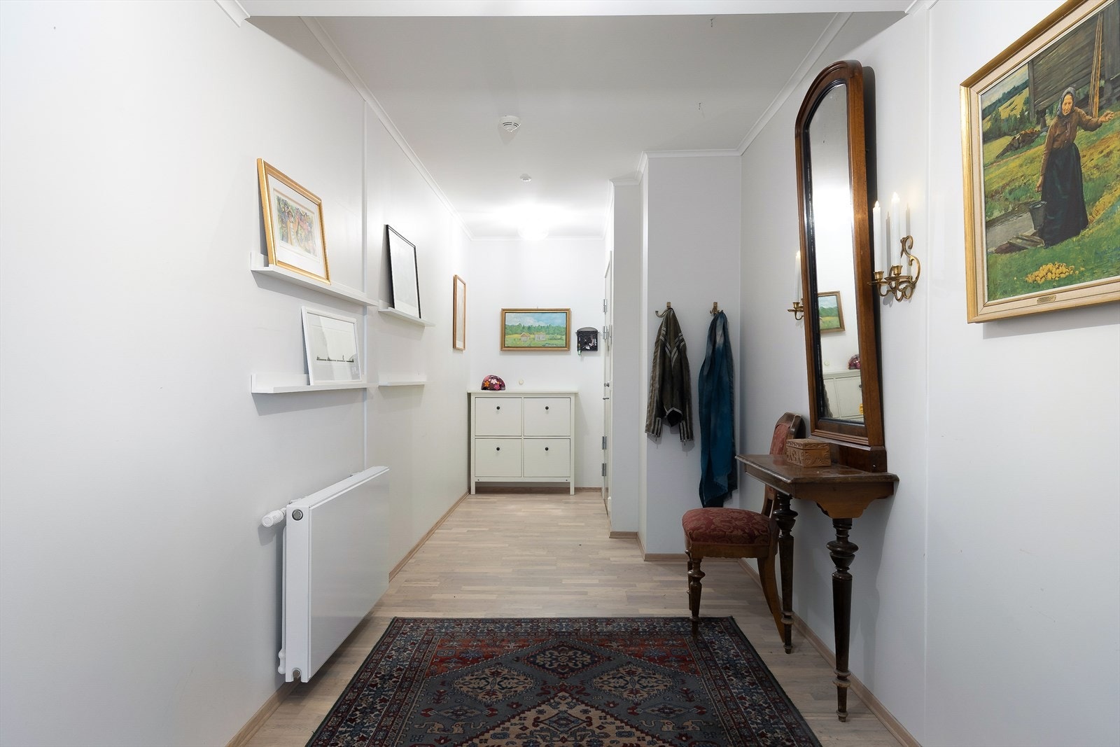 En lys og fin entré ønsker deg velkommen inn i leiligheten hvor det er god plass til sko og yttertøy. Galleribilde
