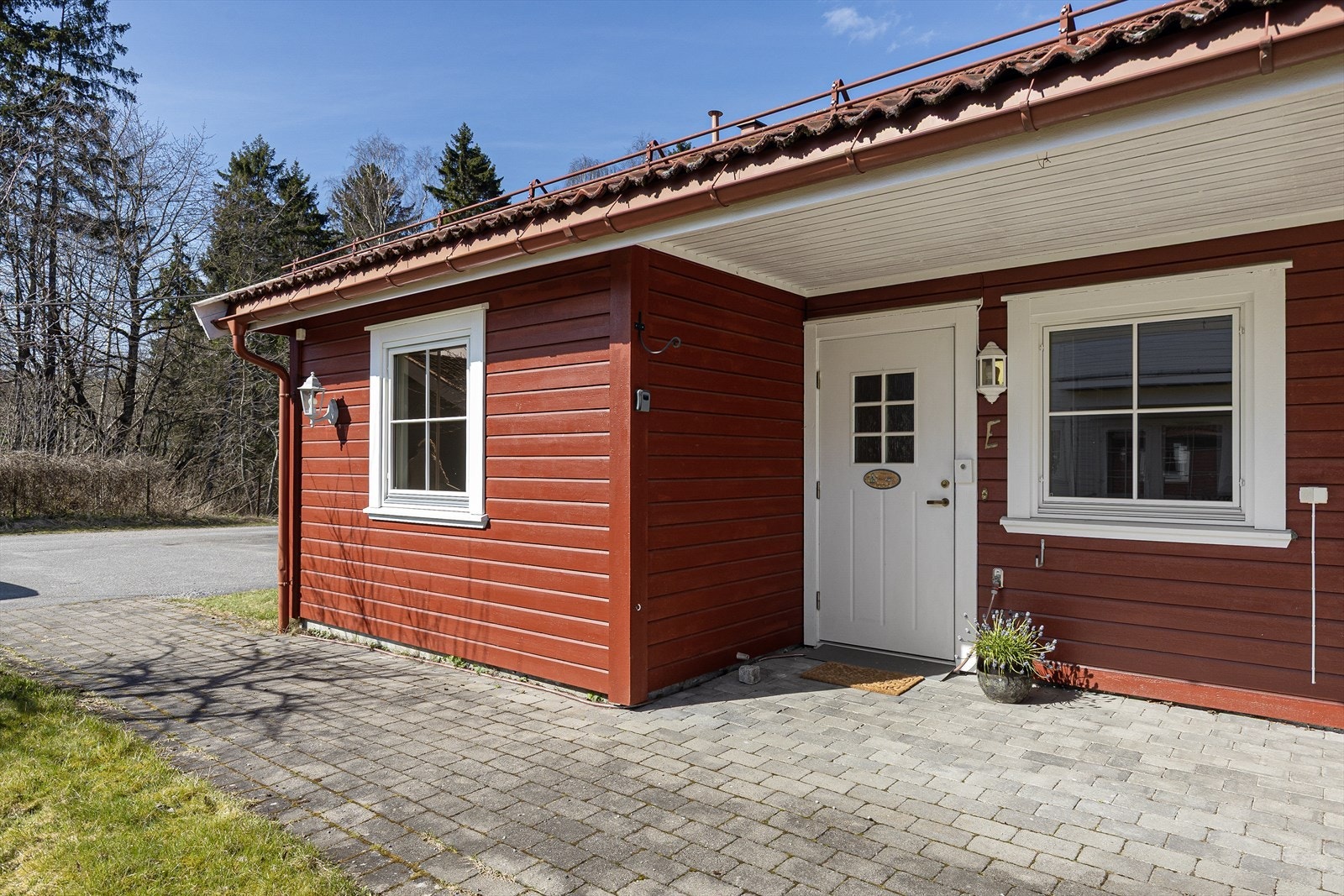 Boligen har et koselig, overbygget inngangsparti med belegningsstein mot sydøst. Galleribilde