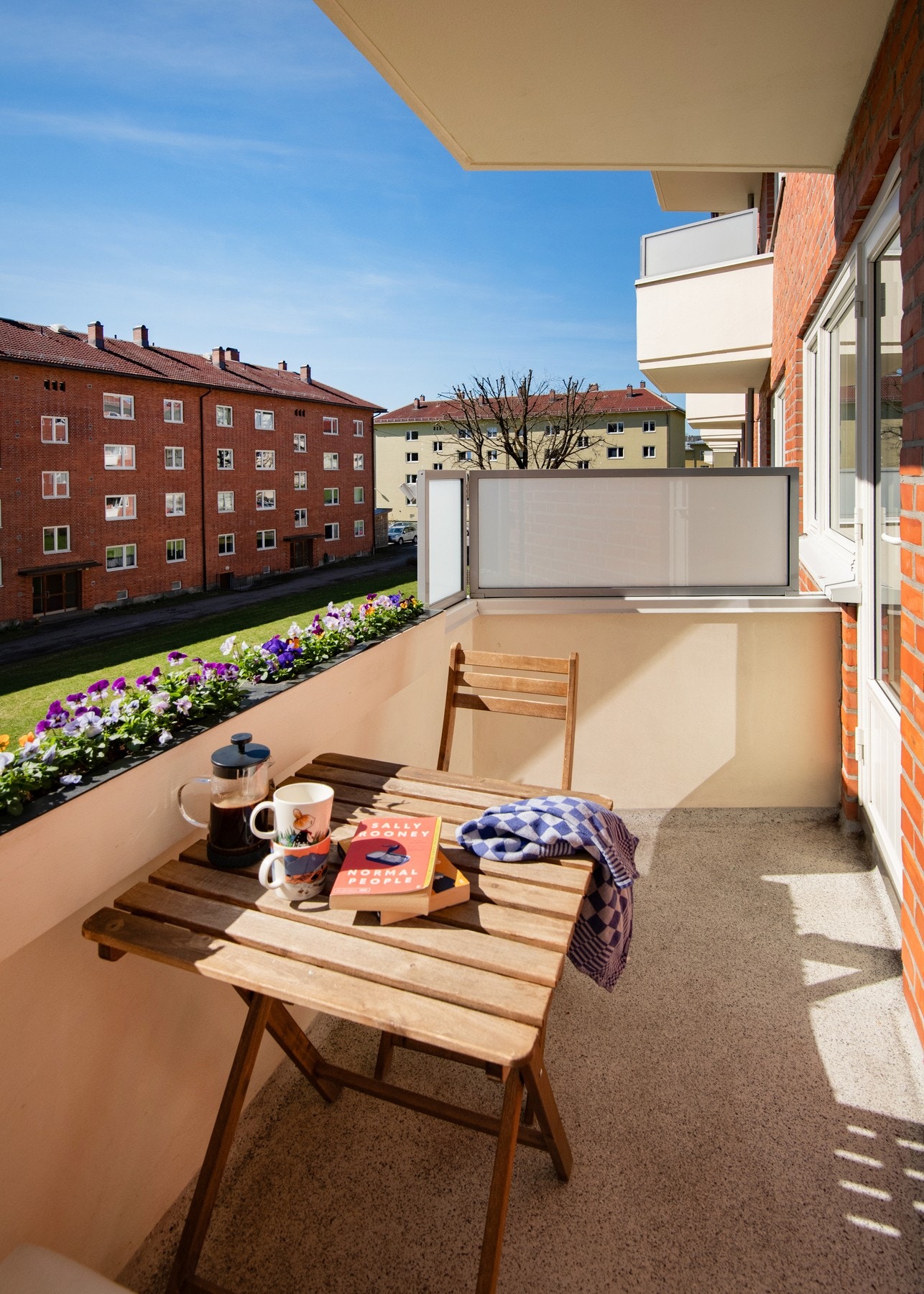 Balkongen har blomsterkasser som legger til rette for beplantning og skaper en frodig, grønn ramme rundt uteplassen. Galleribilde