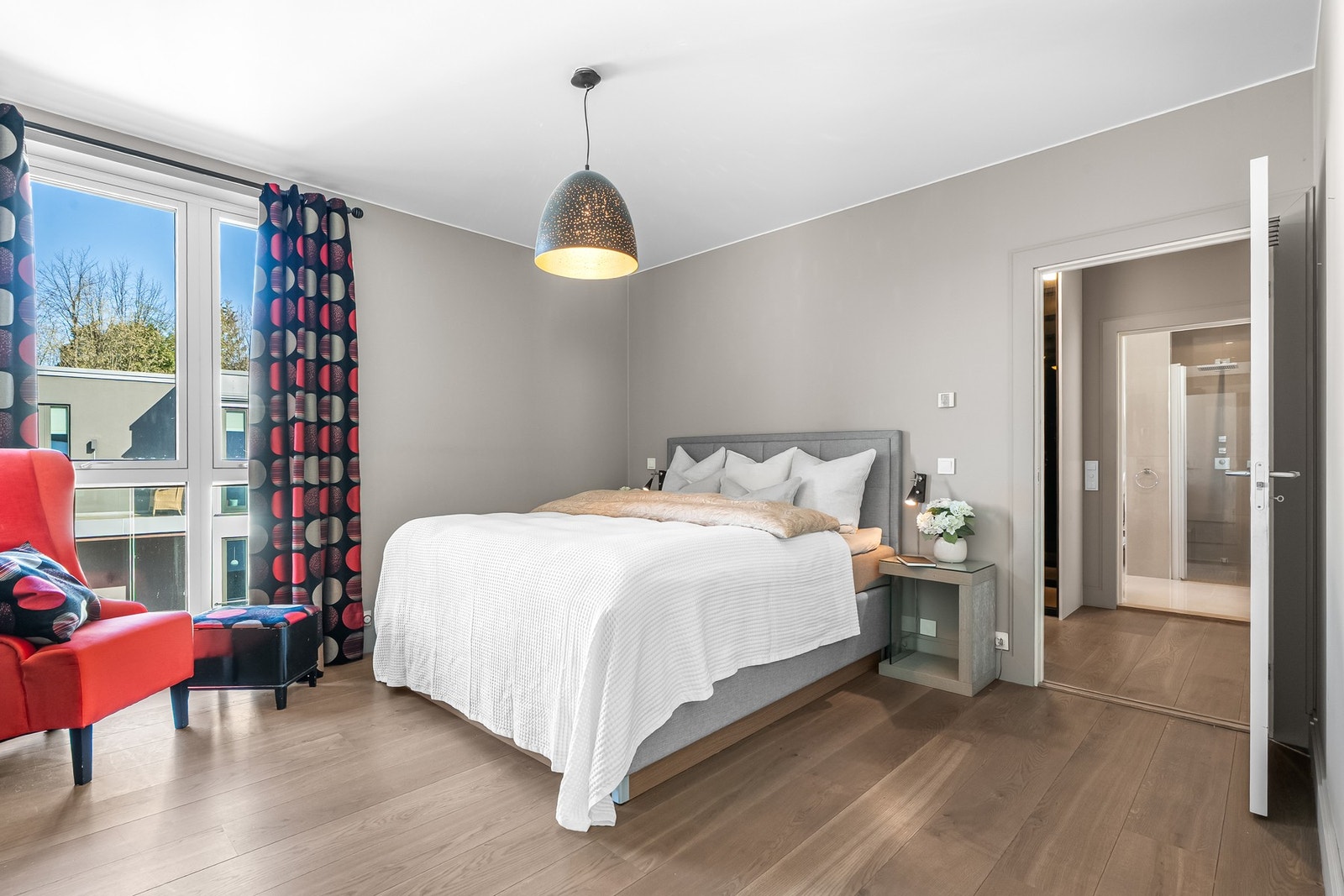 Lyst og luftig hovedsoverom med eget bad og romslig walk-in-closet Galleribilde