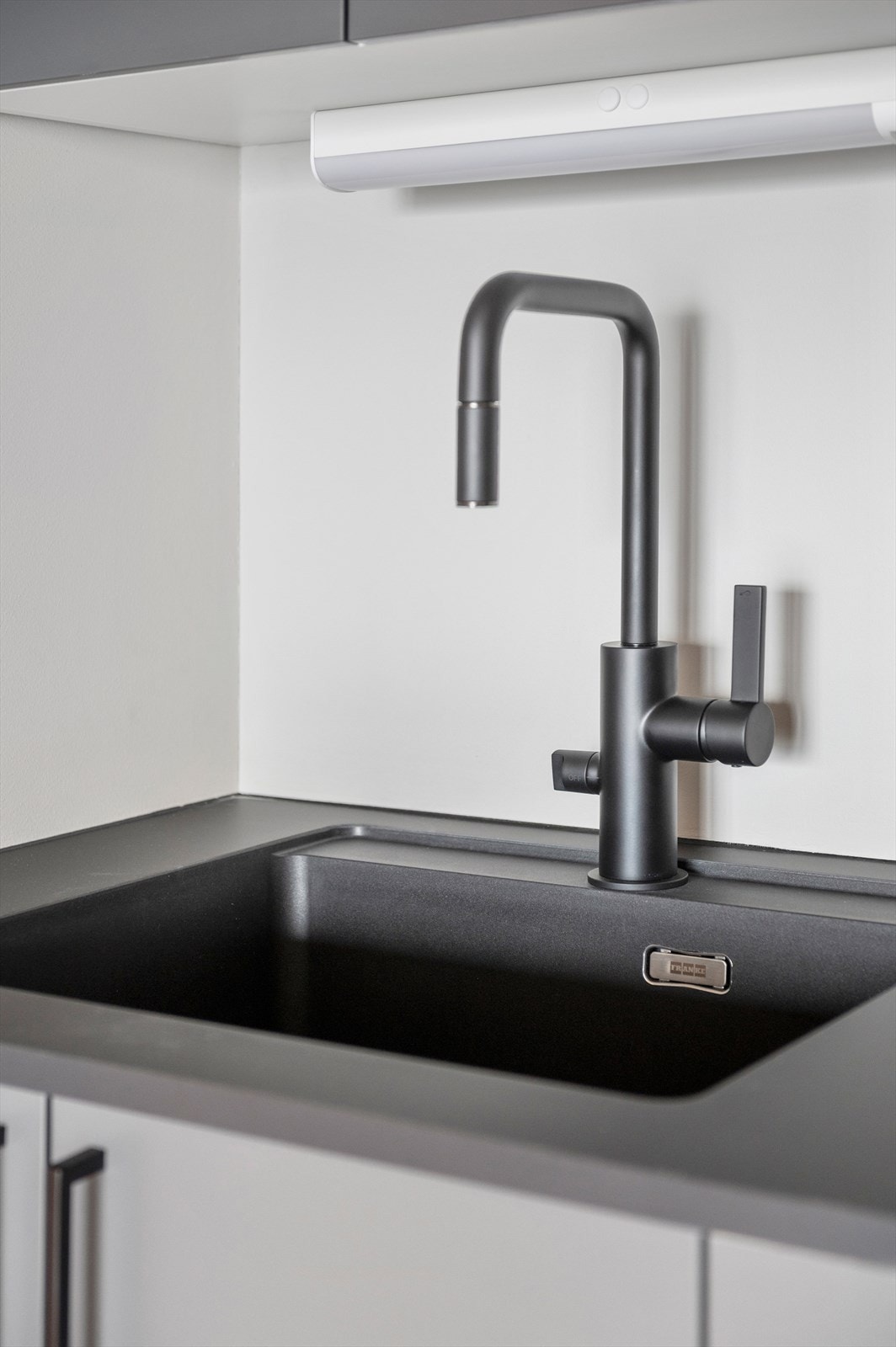 Kjøkkenet er utstyrt med innredning med mørke glatte fronter, benkeplate i laminat med nedfelt oppvaskkum med blandebatteri. Galleribilde
