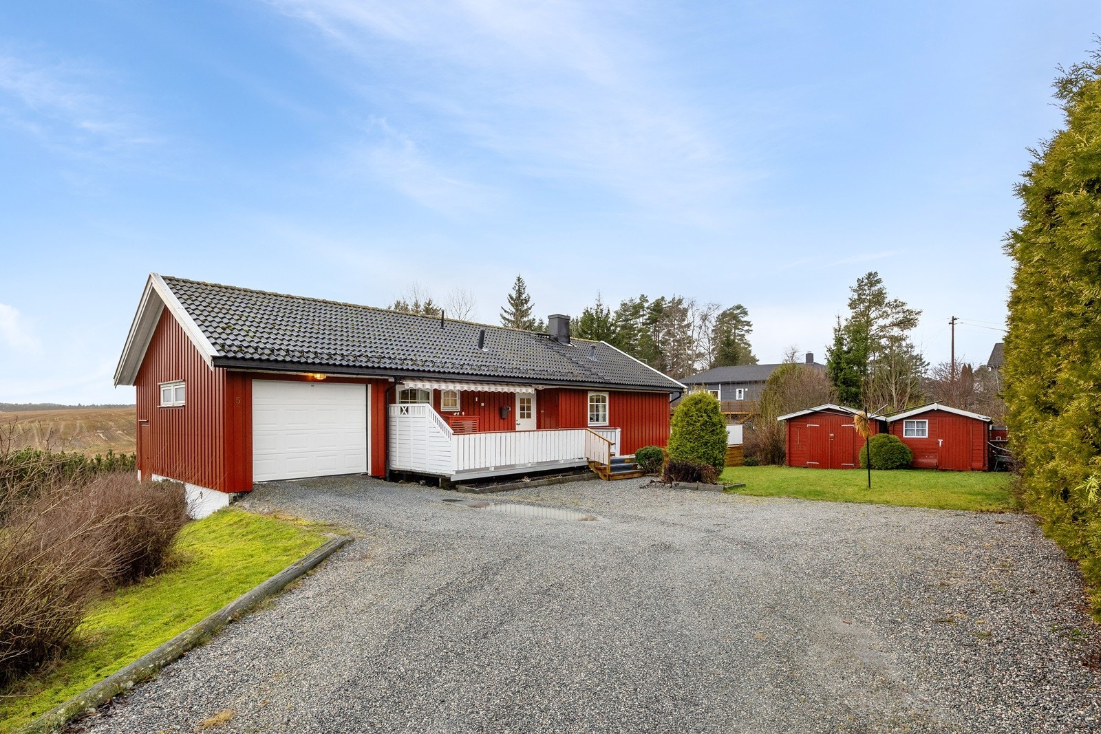 Eneboligen har en integrert garasje med elektrisk portåpner og et areal på ca. 19 kvm. Garasjen er platekledd innvendig, og foran huset finner man en gruslagt gårdsplass for ytterligere parkering. Galleribilde
