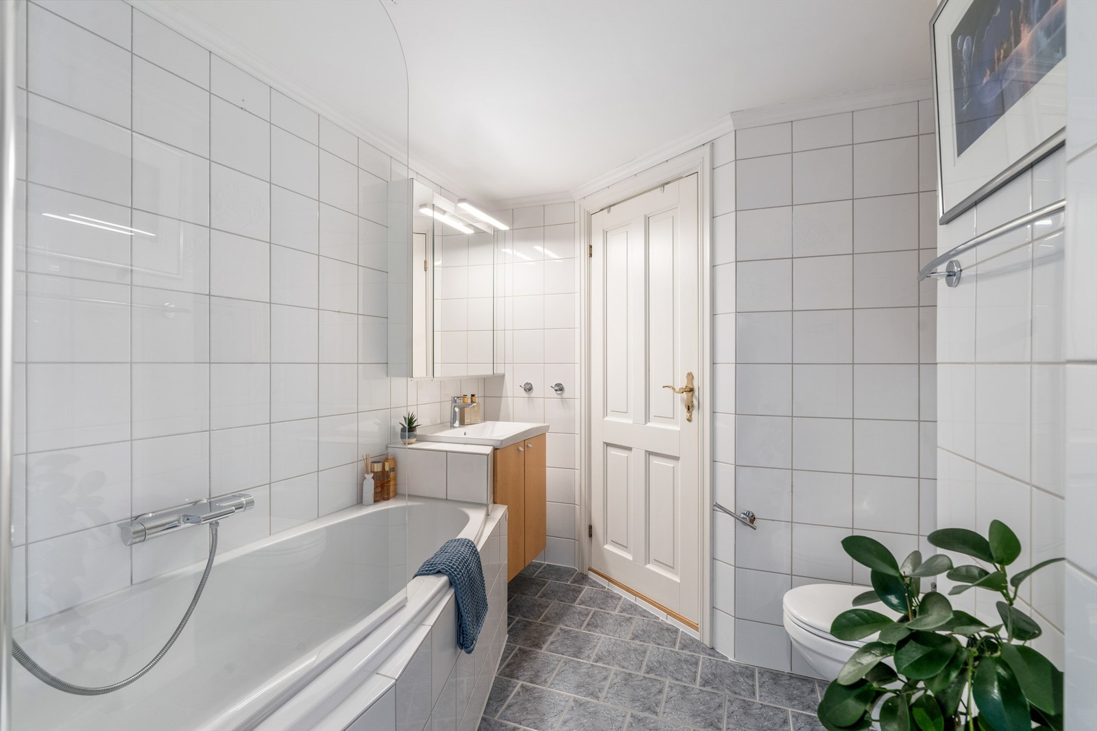 Badet er utstyrt med varmekabler i gulv, vegghengt servant og toalett og badekar. Galleribilde