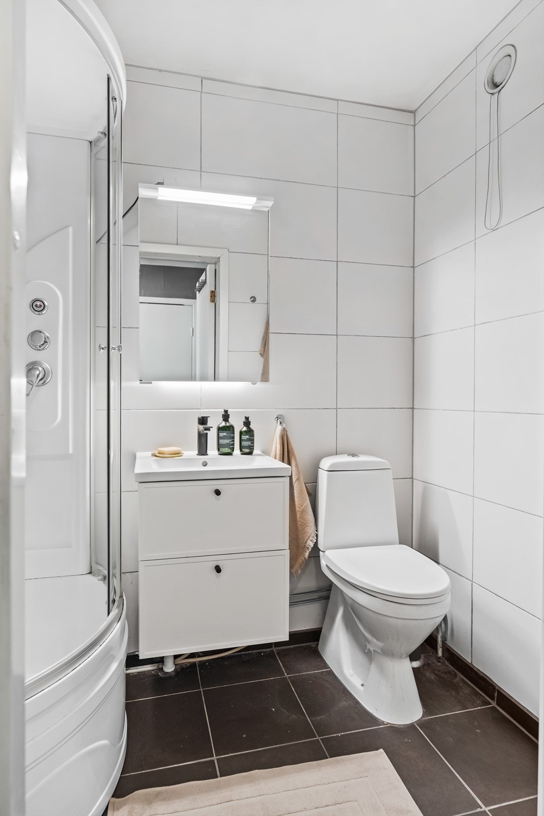 Badet har fliser på gulv og vegger, samt slette overflater i himlingen. Galleribilde