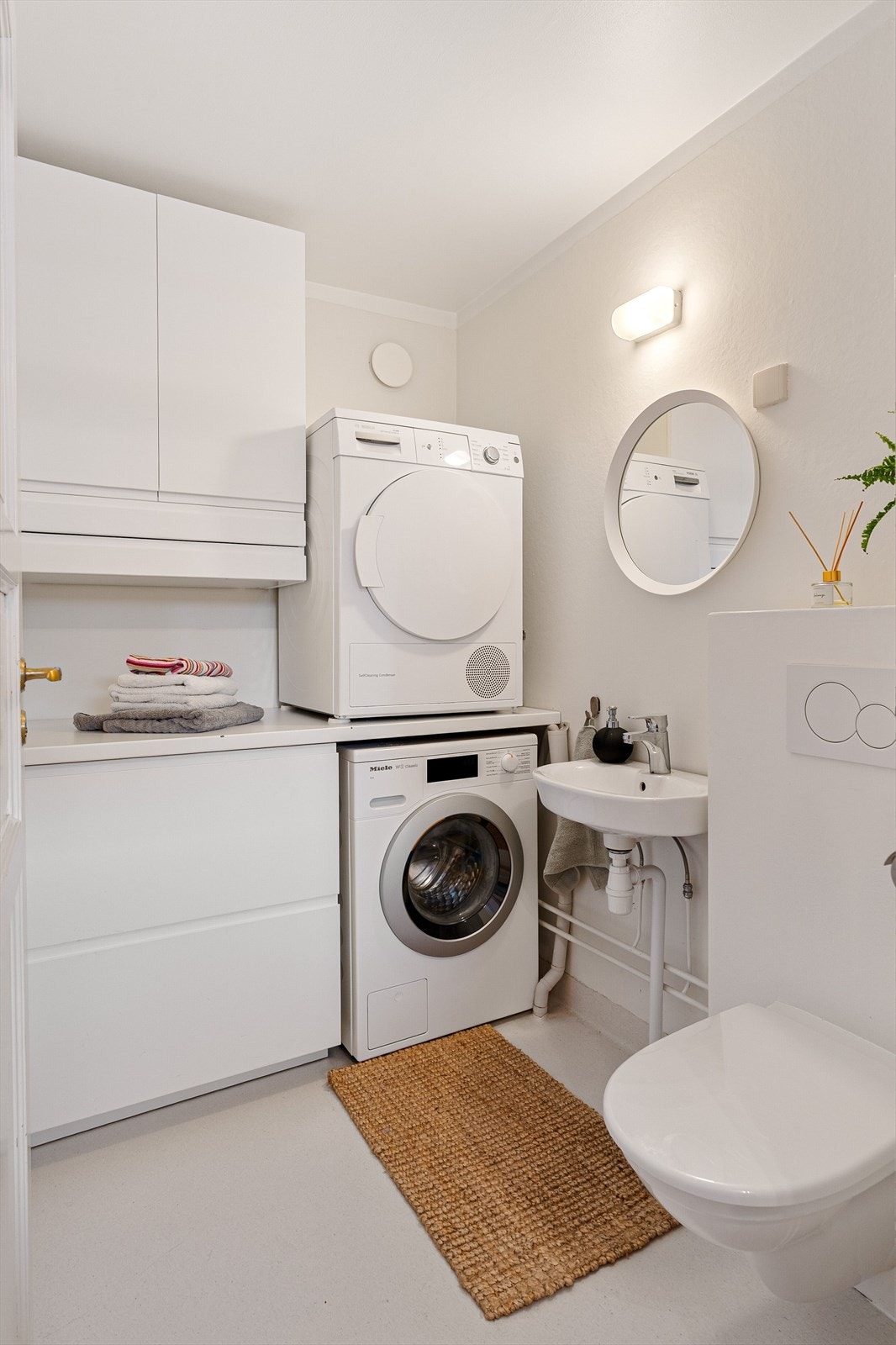 Vaskerommet har effektive arbeidsflater og god oppbevaringsplass. Rommet har i tillegg toalett og servant som et praktisk supplement til rekkehusets hovedbad. Galleribilde