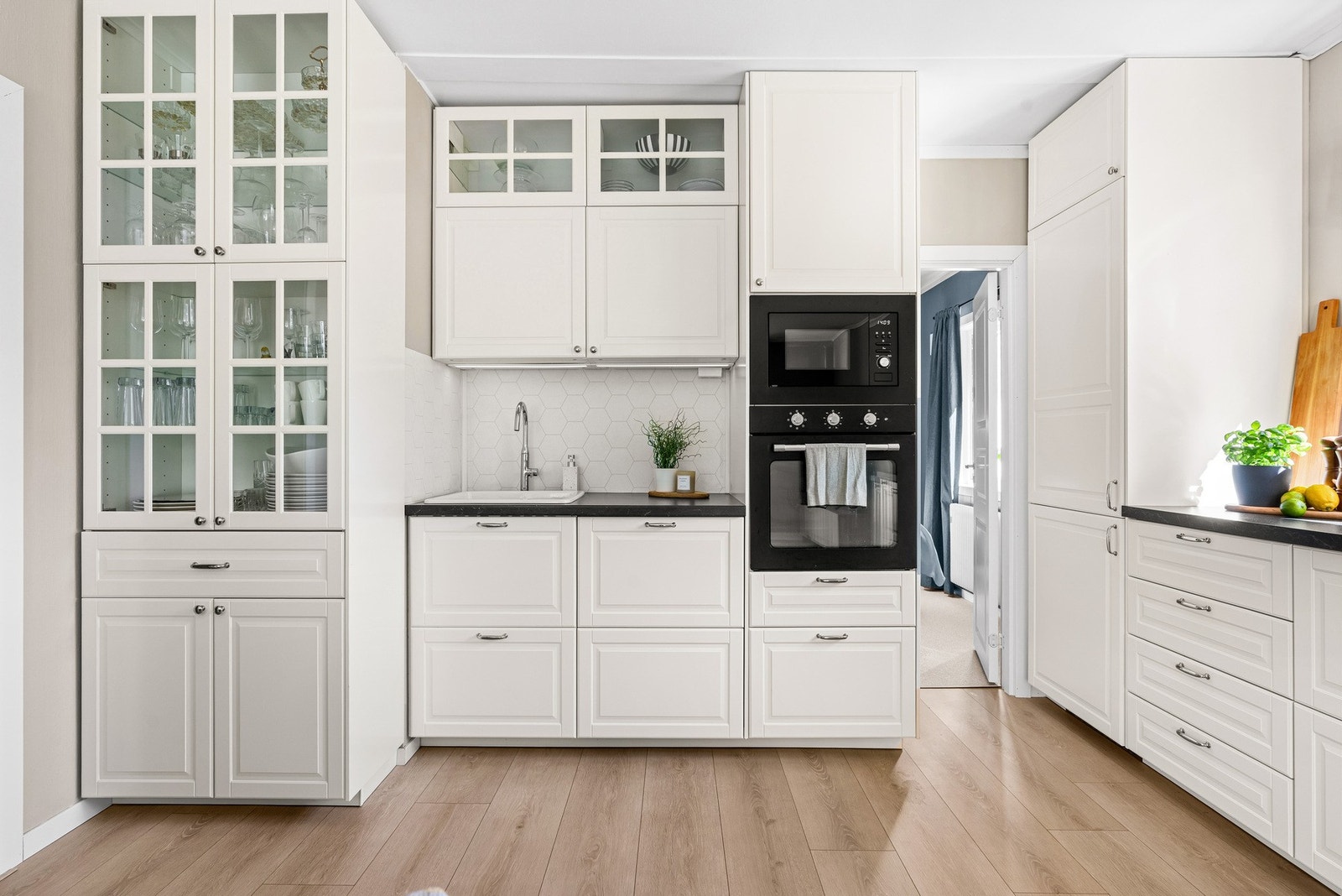 Innredningen fra Ikea har profilerte fronter med dempefunskjoner, kombinert med benkeplater i laminat, fliser over benken og vaskekum i porselen. Galleribilde