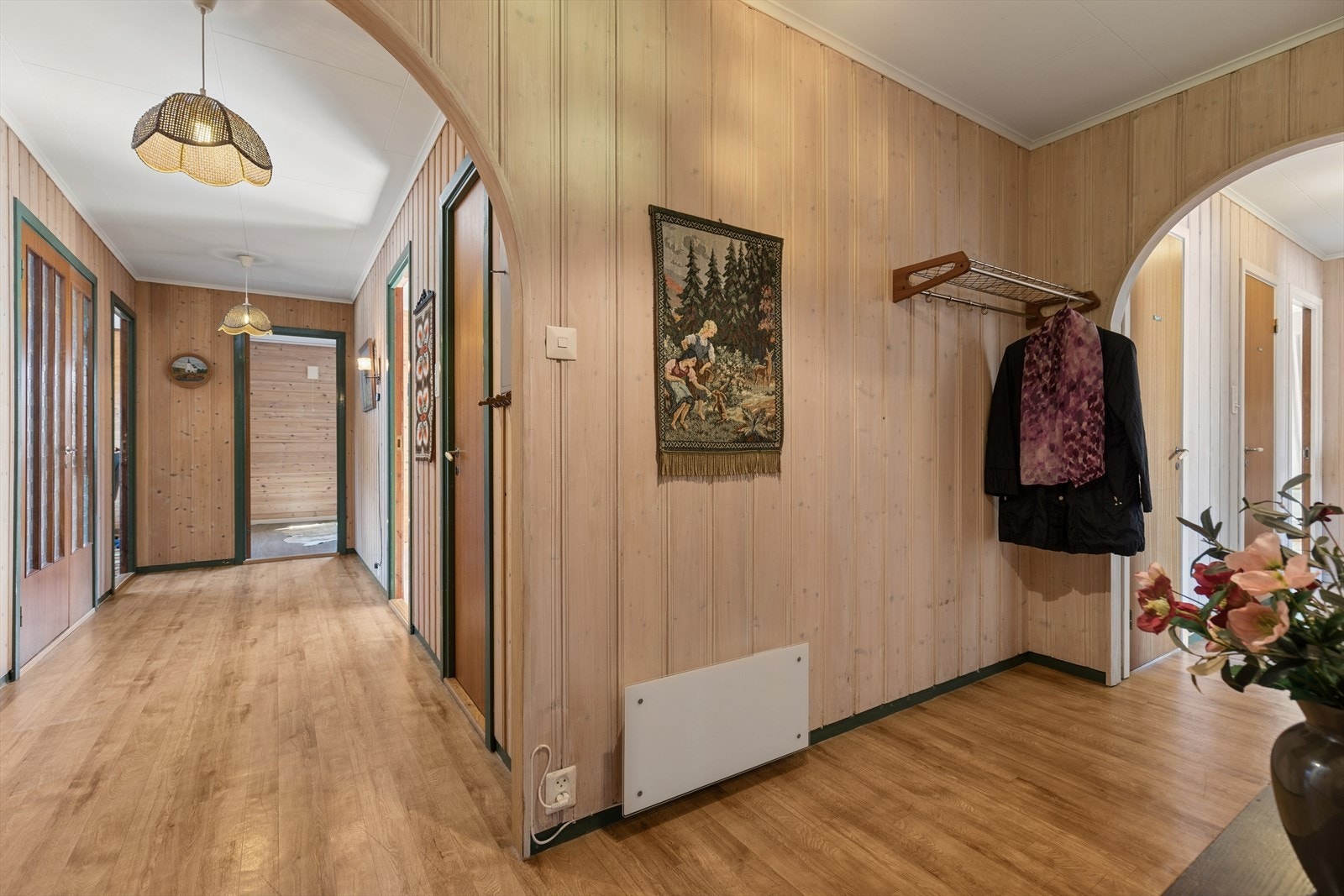 Entréen og gangen binder boligens ulike soner sammen. Veggene har i hovedsak panel, som gir en lun velkomst. Galleribilde