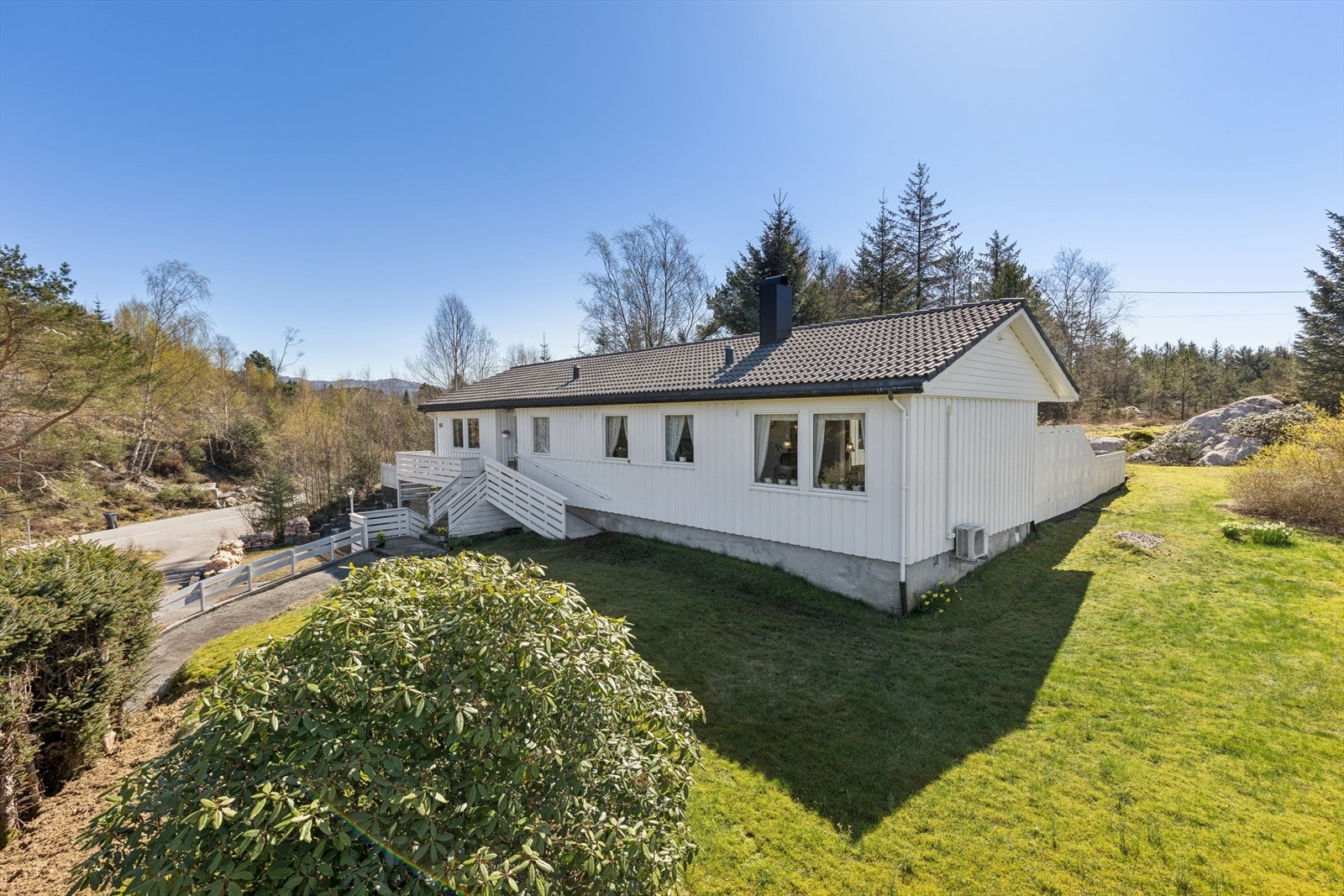 Eiendommen ligger på en pent opparbeidet tomt med plen og beplantning. Galleribilde