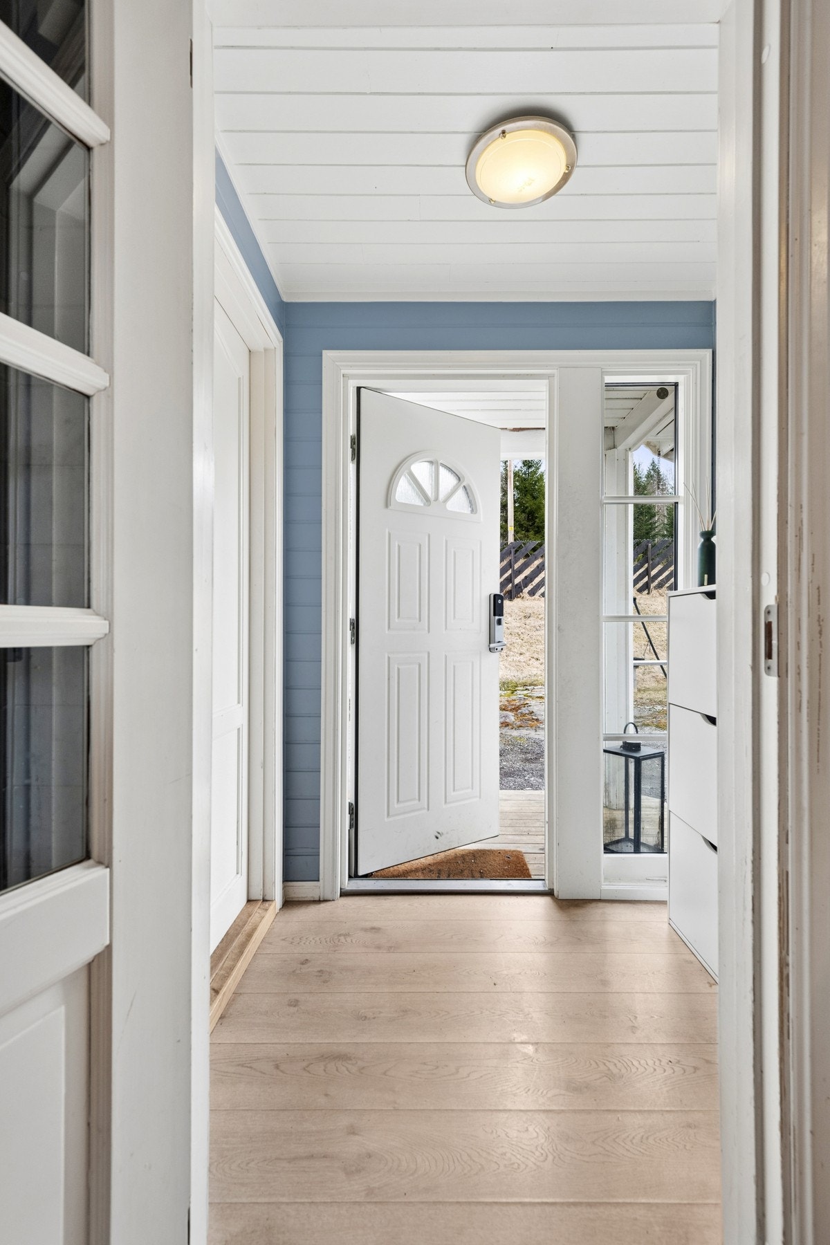 Entré fremstår som lys og innbydende med lyse overflater og et pent gulv som er praktisk i bruk. Det er naturlig plass til oppbevaring av yttertøy og sko, og entréen gir et ryddig og funksjonelt første møte med boligen. Galleribilde