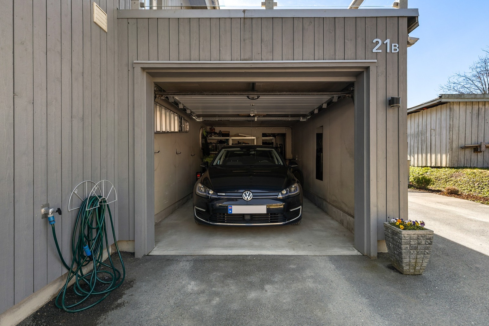 Boligen har gode parkeringsmuligheter i garasje og asfaltert gårdsplass Galleribilde