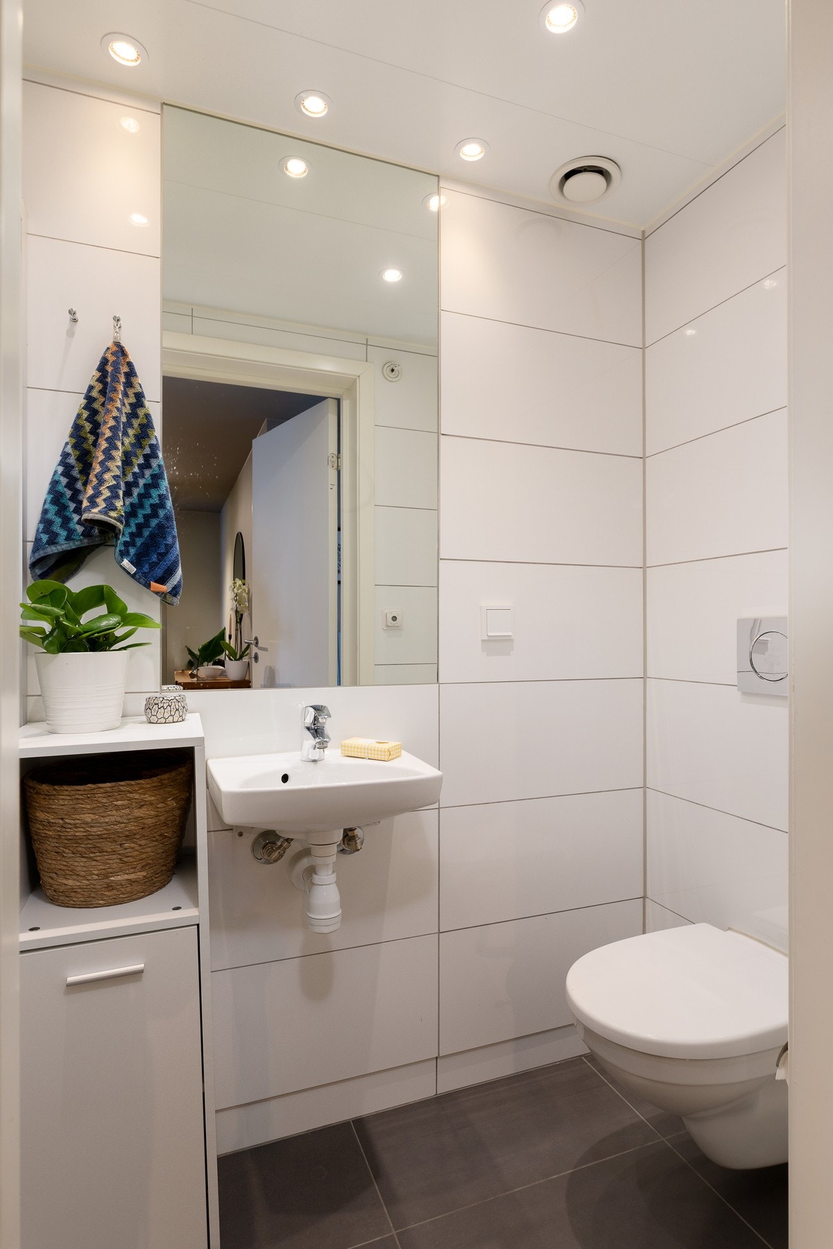 Badet er et prefabrikkert våtrom fra byggeår med flislagte overflater og elektriske varmekabler i gulv. Galleribilde