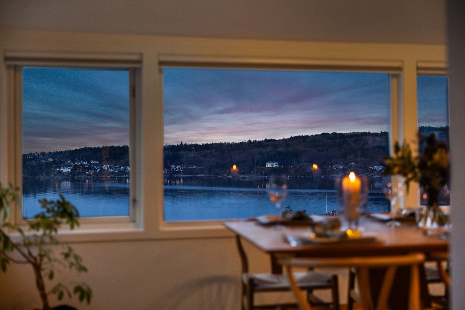 Stue med store vindusflater som tar inn utsikten over sjøen og området. Galleribilde