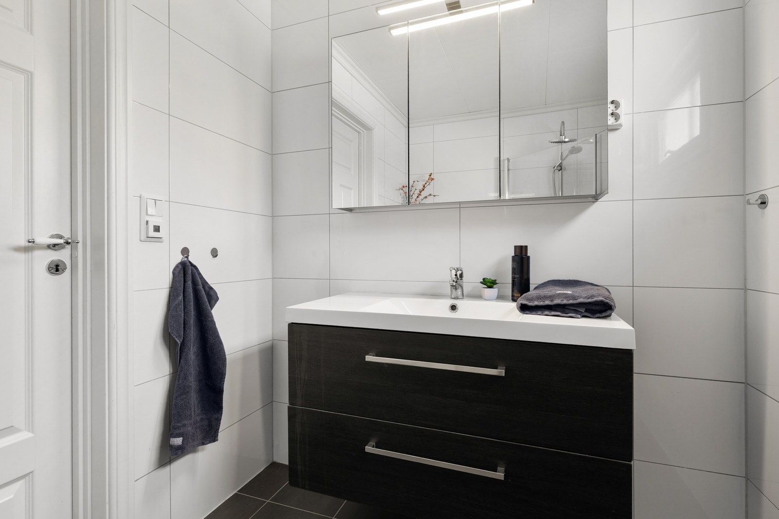 Videre er badet utstyrt med servantinnredning og speilskap Galleribilde