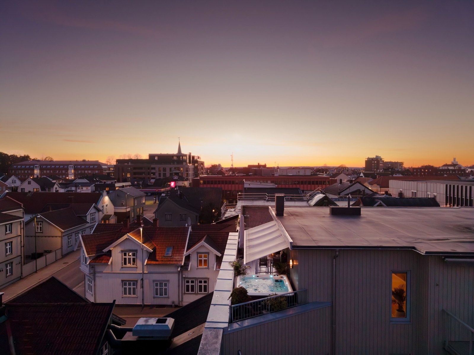 På taket med byen nedenfor og kveldssolen i horisonten Galleribilde