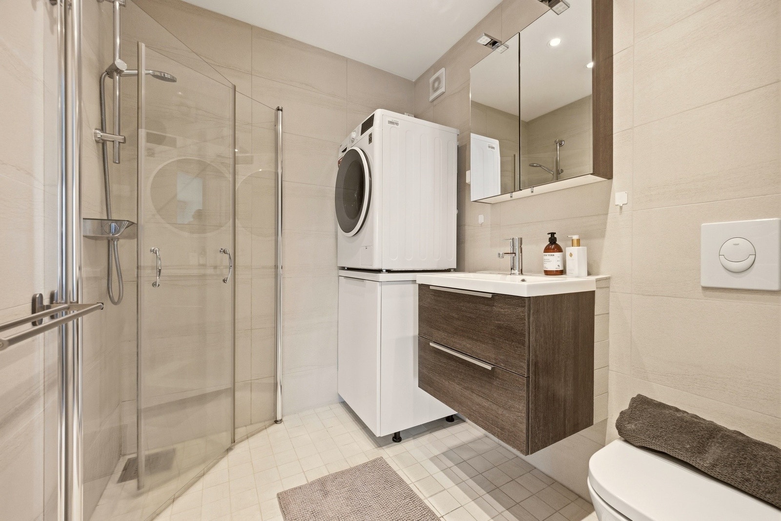Badet ved garasjen har flislagte gulv og vegger, samt hvitmalt slett tak. Galleribilde