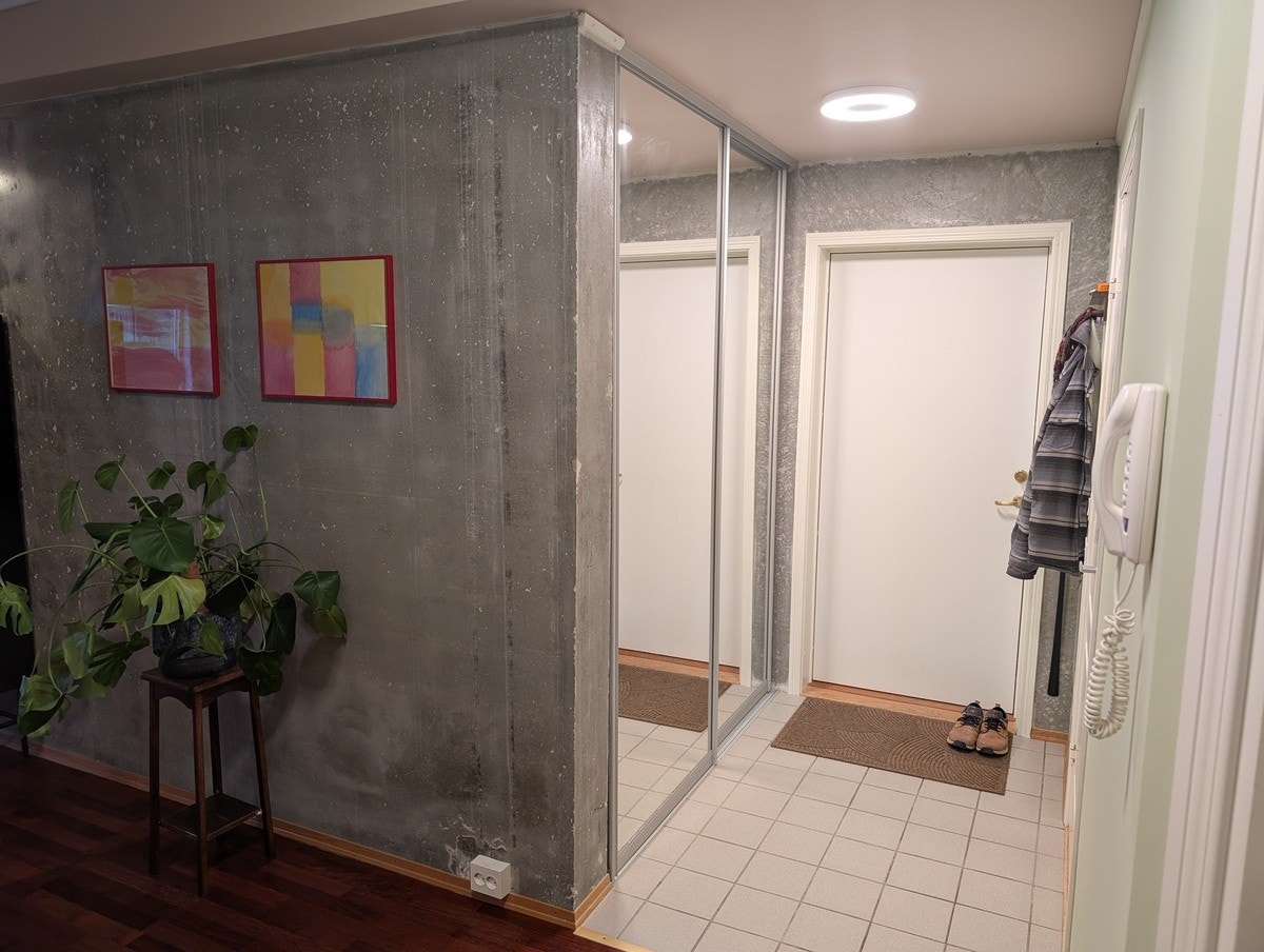 Inngangsparti med skyvedørsgarderobe som har stang og trådkurver. Galleribilde