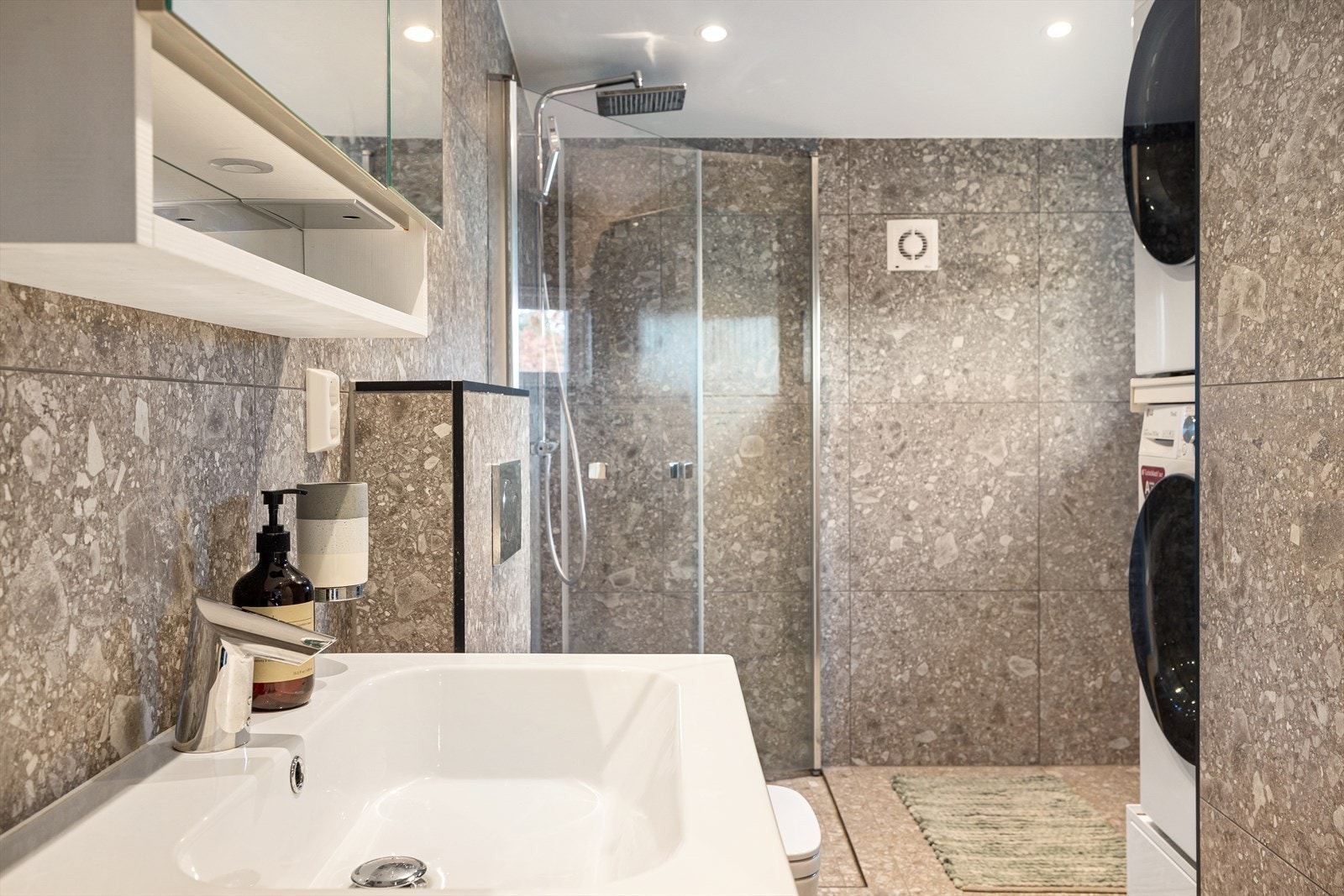 Badet rommer opplegg til vaskemaskin, plass til tørkestativ, romslig innredning og en fin dusjkrok. Galleribilde