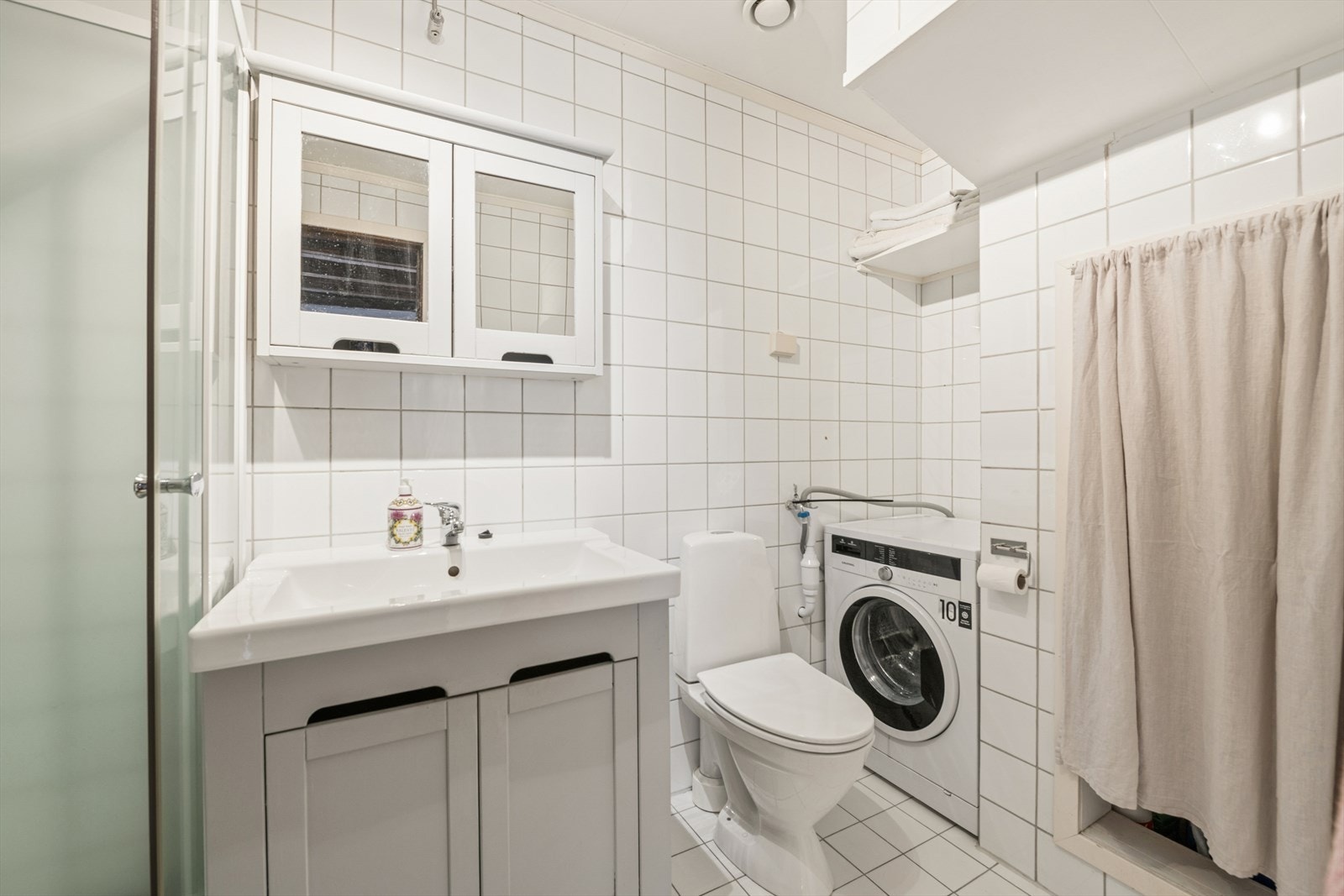 Leiligheten har et romslig bad i hovedetasjen med flislagt gulv og vegger, samt varmekabler. Det er en naturlig seksjon med plass for vaskemaskin og tørketrommel. Det er i tillegg godt med oppbevaringsplass. Galleribilde