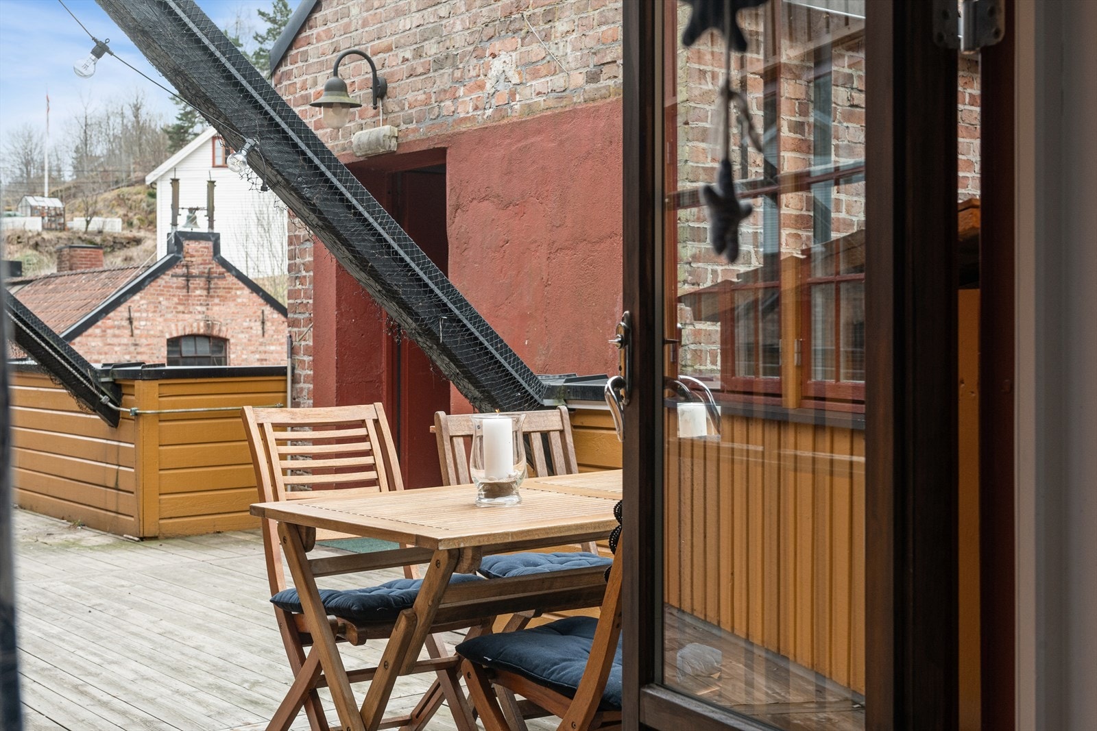 Fra rommet er det direkte utgang til terrasseområdet. De doble glassdørene slipper rikelig med lys inn og visker ut skillet mellom inne og ute. Galleribilde
