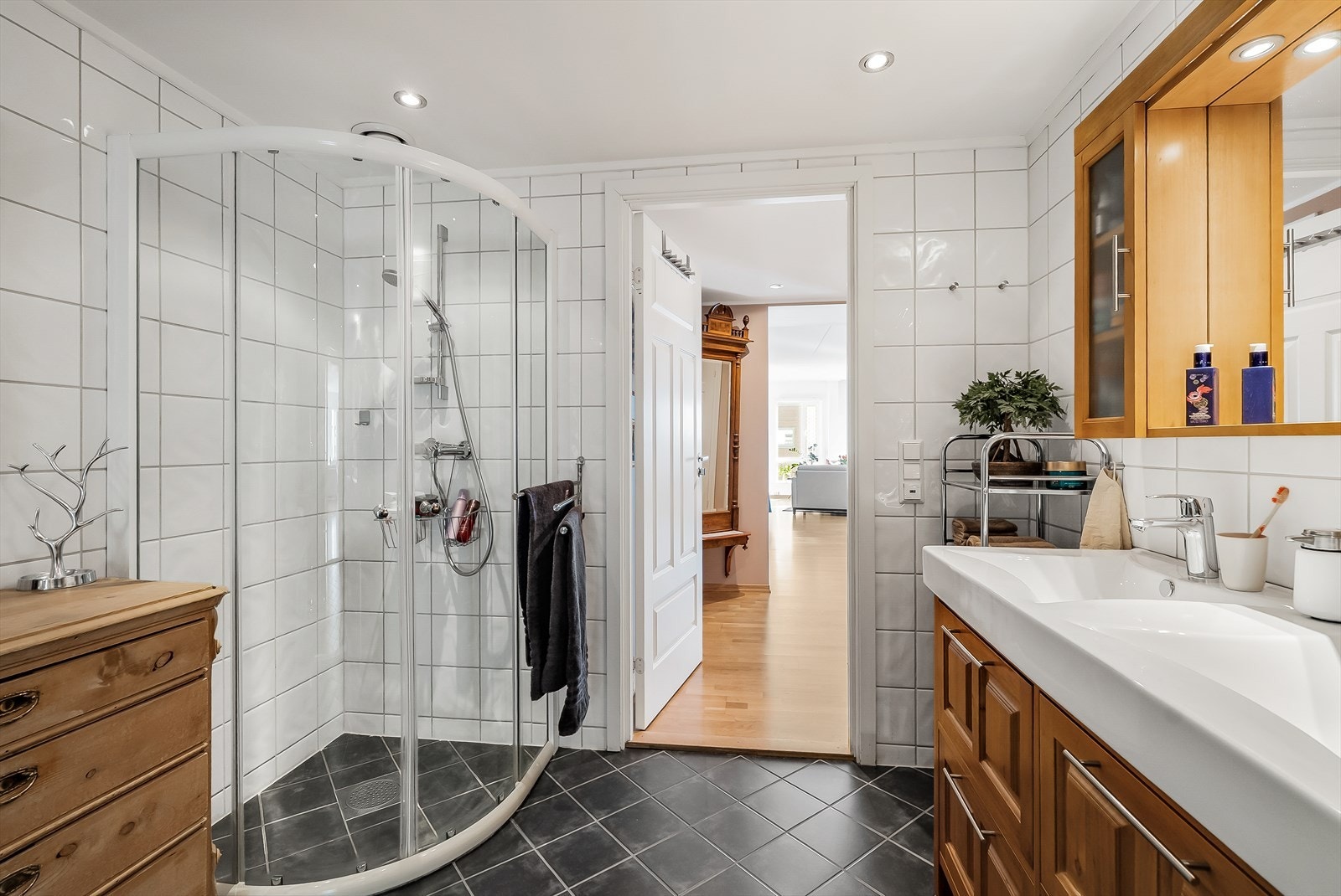 Badet er utstyrt med dusjnisje med glassdører, toalett og baderomsinnredning med dobbel servant. Galleribilde