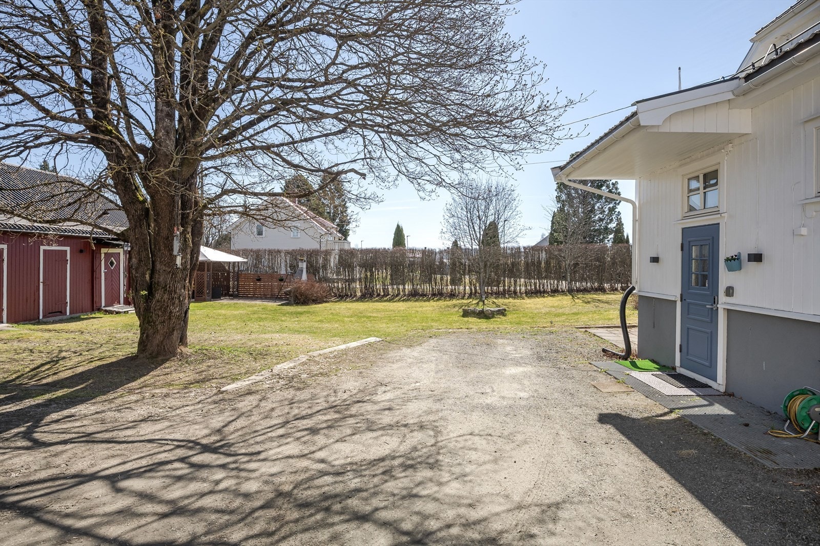 Gruset gårdsplass med parkeringsmuligheter. Galleribilde