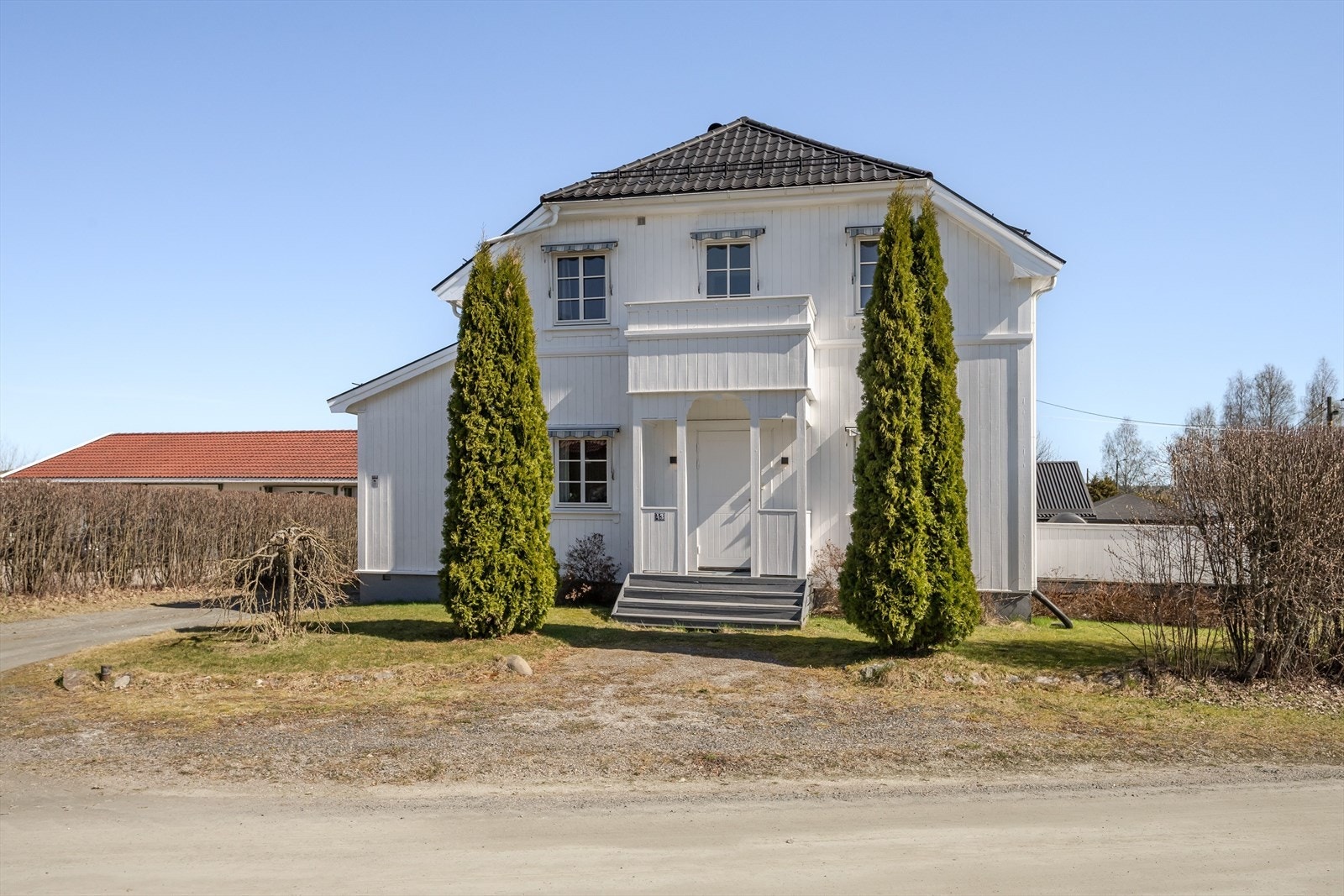Sekundærentré med tretrapp og takoverbygg tar deg inn til entré hvor det er adkomst til stuen. Galleribilde