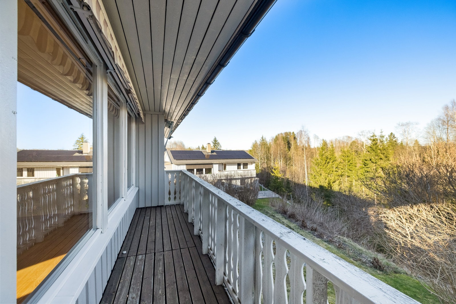 Den ene av stuens to verandaer er bygget i tre og strekker seg langs fasaden. Galleribilde