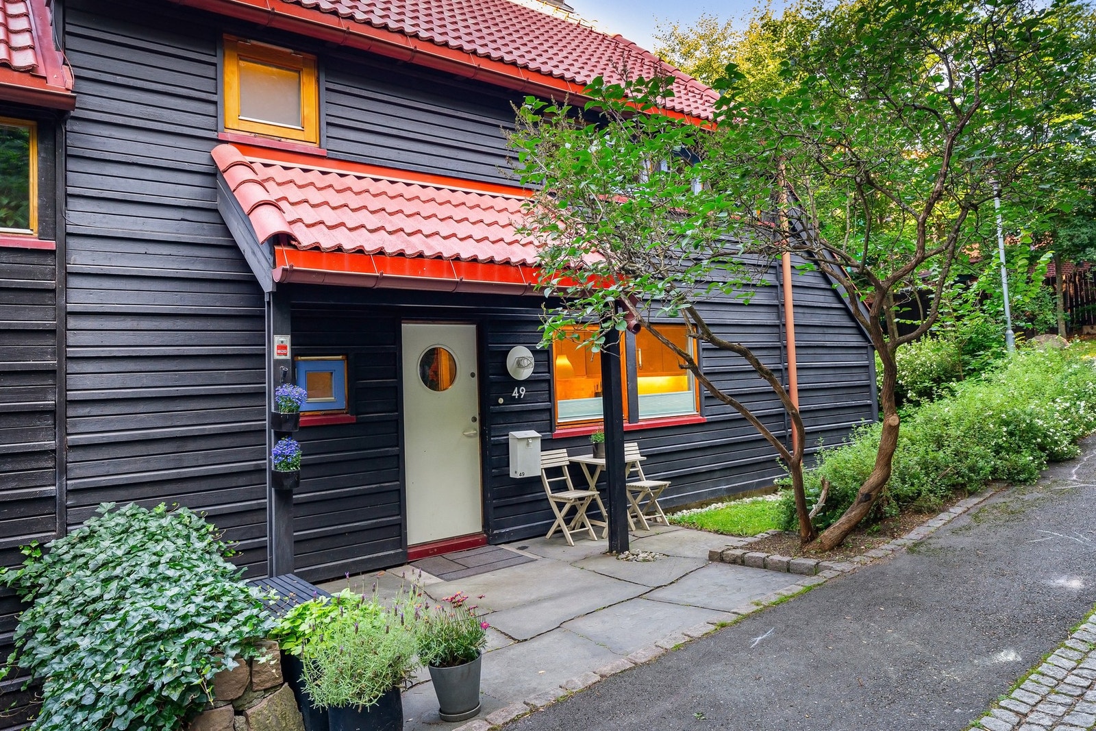 Inngangspartiet gir et godt førsteinntrykk, med fine planter, store skiferfliser og plass til et koselig kafésett. Ytterdøren er overbygd, utstyrt med belysning og ringeklokke. Galleribilde