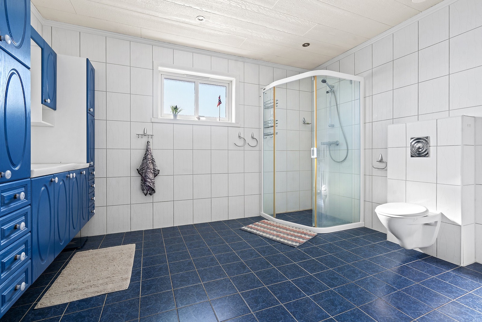 Romslig baderom med opplegg for vaskemaskin i hovedplan Galleribilde
