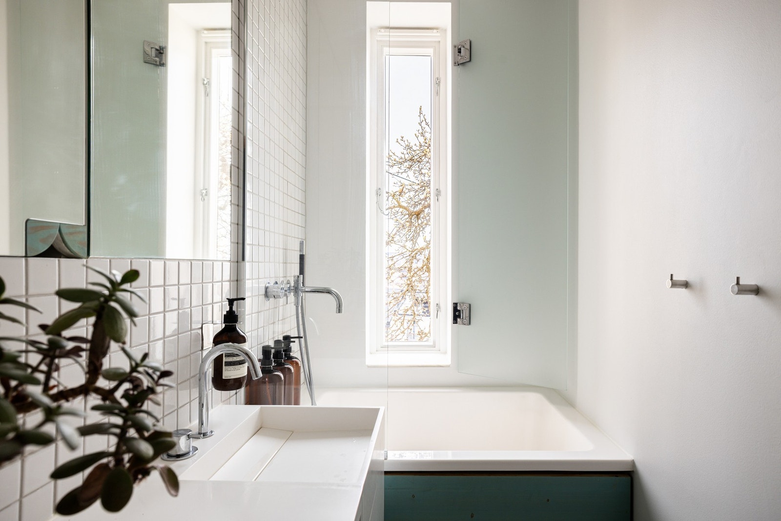 Innerst i rommet er det et badekar med glassvegg og innebygd armatur med både overdusj, hånddusj og badekran. Alle armaturer på badet er fra danske VOLA. Galleribilde