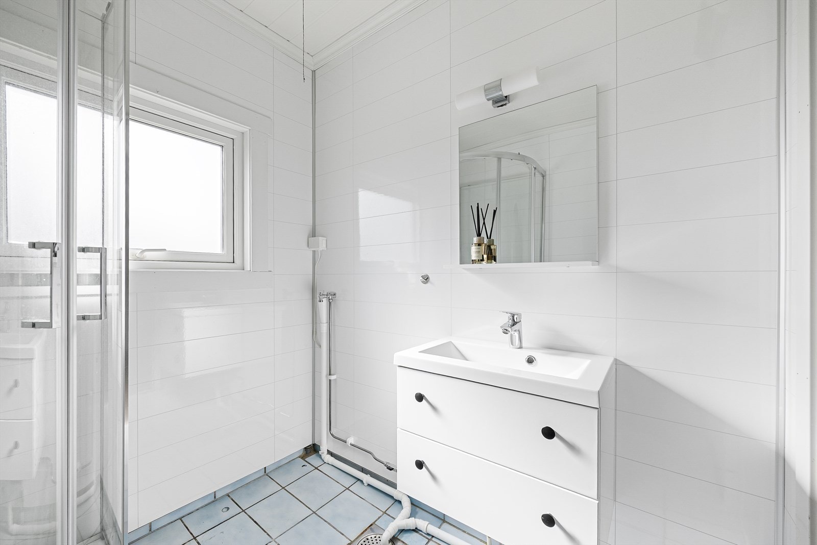 Overflater består av flis på gulv, våtromsplater som er montert i senere tid og malt panel i himling. Galleribilde