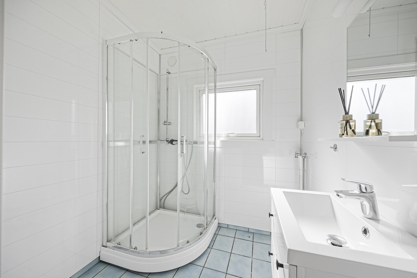 Badet inneholder heldekkende servant med underskap, speil, dusjkabinett og opplegg til vaskemaskin. Galleribilde