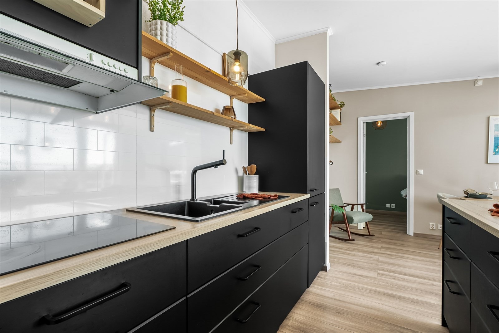 Innredningen har glatte, mørke fronter som gir kjøkkenet et moderne og stilrent uttrykk, kombinert med en lys laminat benkeplate og nedfelt vask. Galleribilde