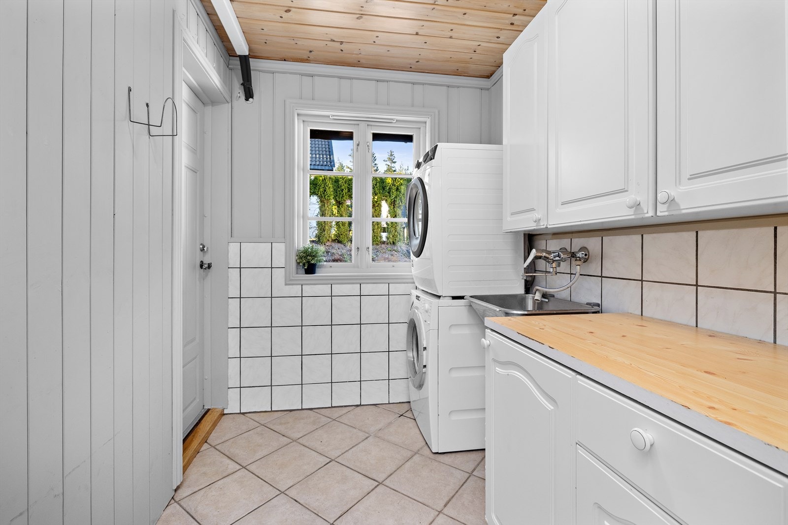 Fra vaskerommet er det egen utgang. Rommet huser også en teknisk nisje med blant annet sentralstøvsugerenhet. Galleribilde